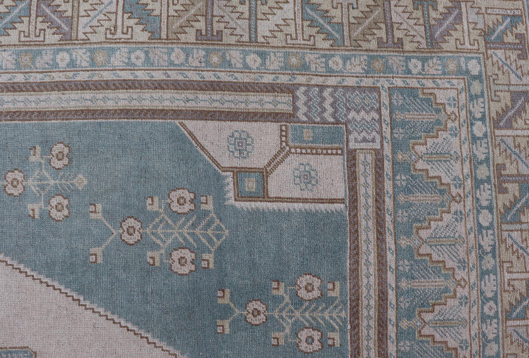 Faded vintage Turkish Oushak rug with Central Medallion in cream and blue, 
rug TU-MTU-6011, country of origin / type: Turkey / Oushak, circa 1940

This sublime and enchanting vintage rug, a gorgeous Oushak rug made in Turkey during the mid-20th