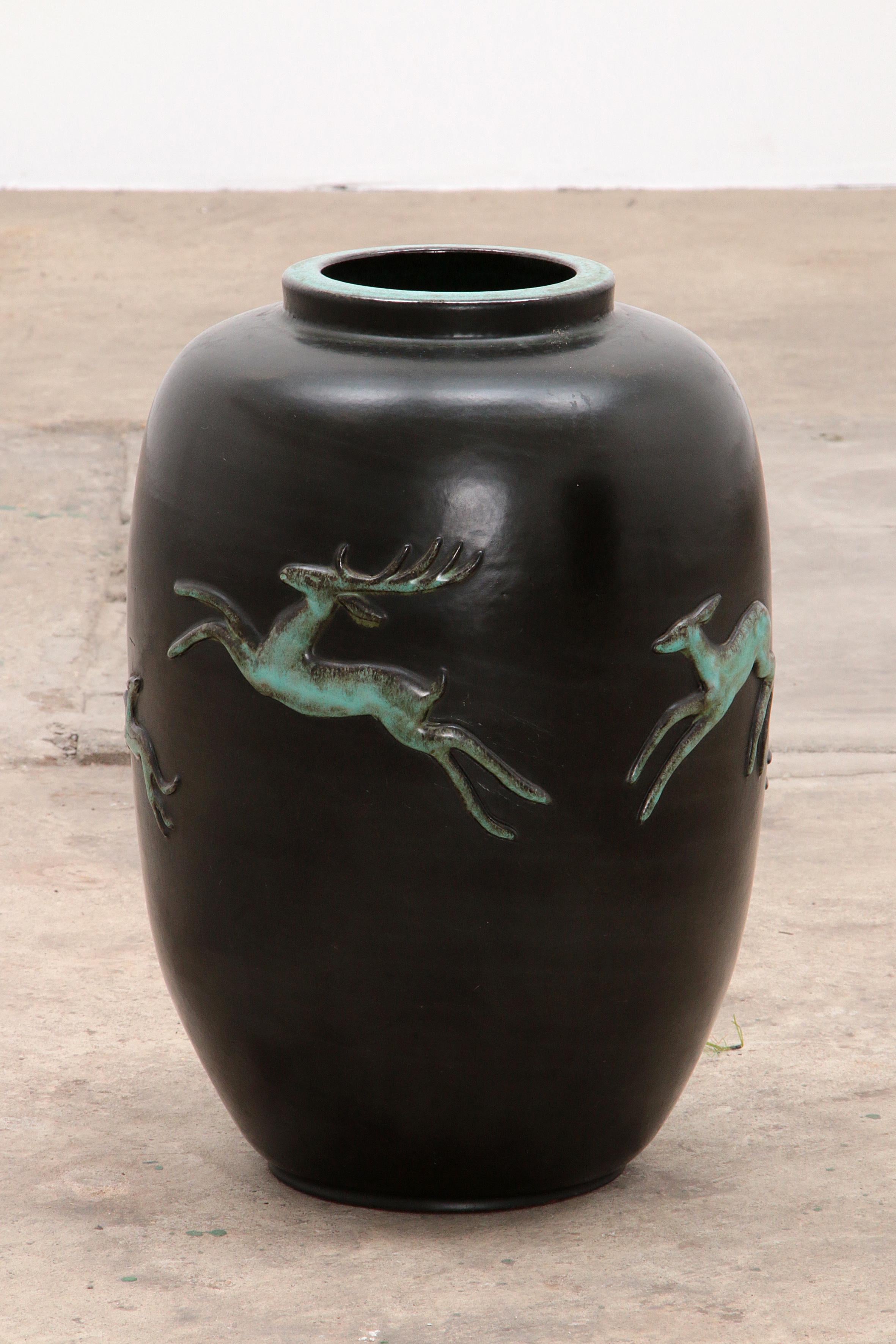 Large glazed black-green terracotta vase from the 1950s with deer in bas-relief made by Ugo Zaccagnini & Son.s. Beautiful, unique piece in very good condition.

This beautiful vase is handmade and glazed with several beautiful jumping deer in a