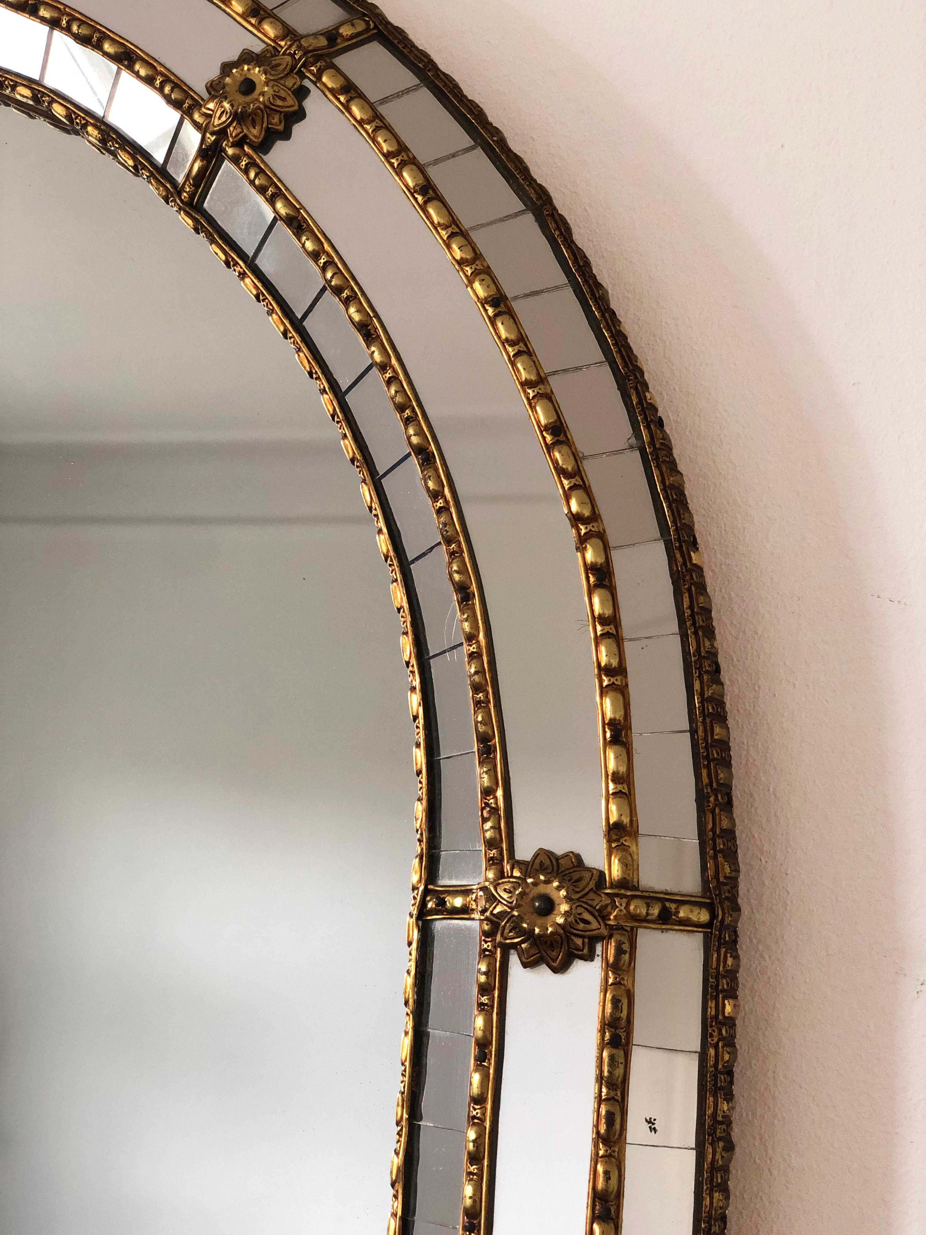 Vintage Venetian large mirror in Spanish style, dating back to the 1990s.
The frame is beautifully hand-crafted and decorated with small crystals on the outer and inner edges, with larger crystals running along the center. The elegant brass strip