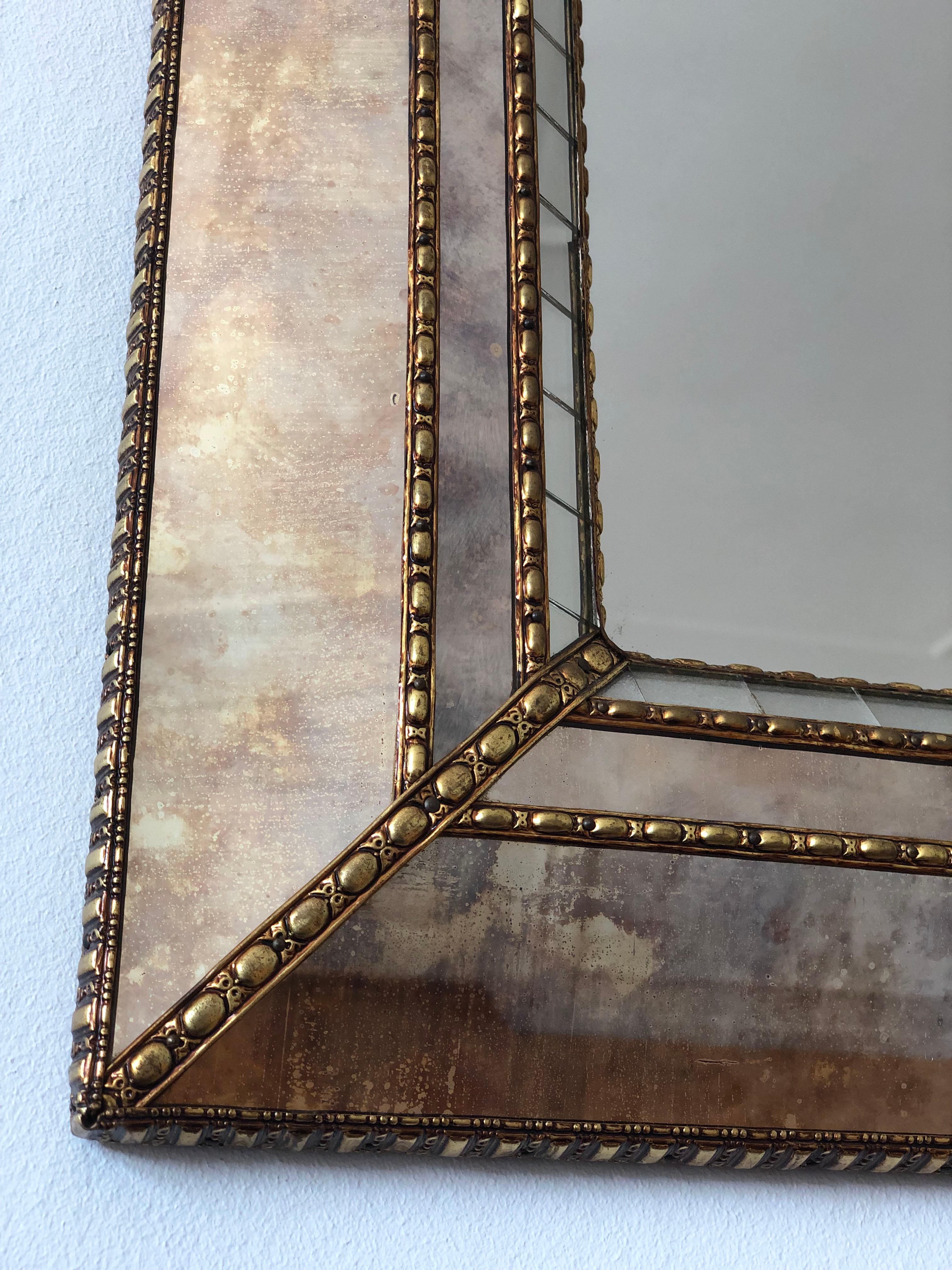 Grande specchio smussato veneziano vintage in stile spagnolo, risalente agli anni '90.
La cornice in vetro fumé è splendidamente lavorata a mano e decorata con piccoli cristalli sui bordi esterni e interni, con cristalli più grandi che corrono lungo