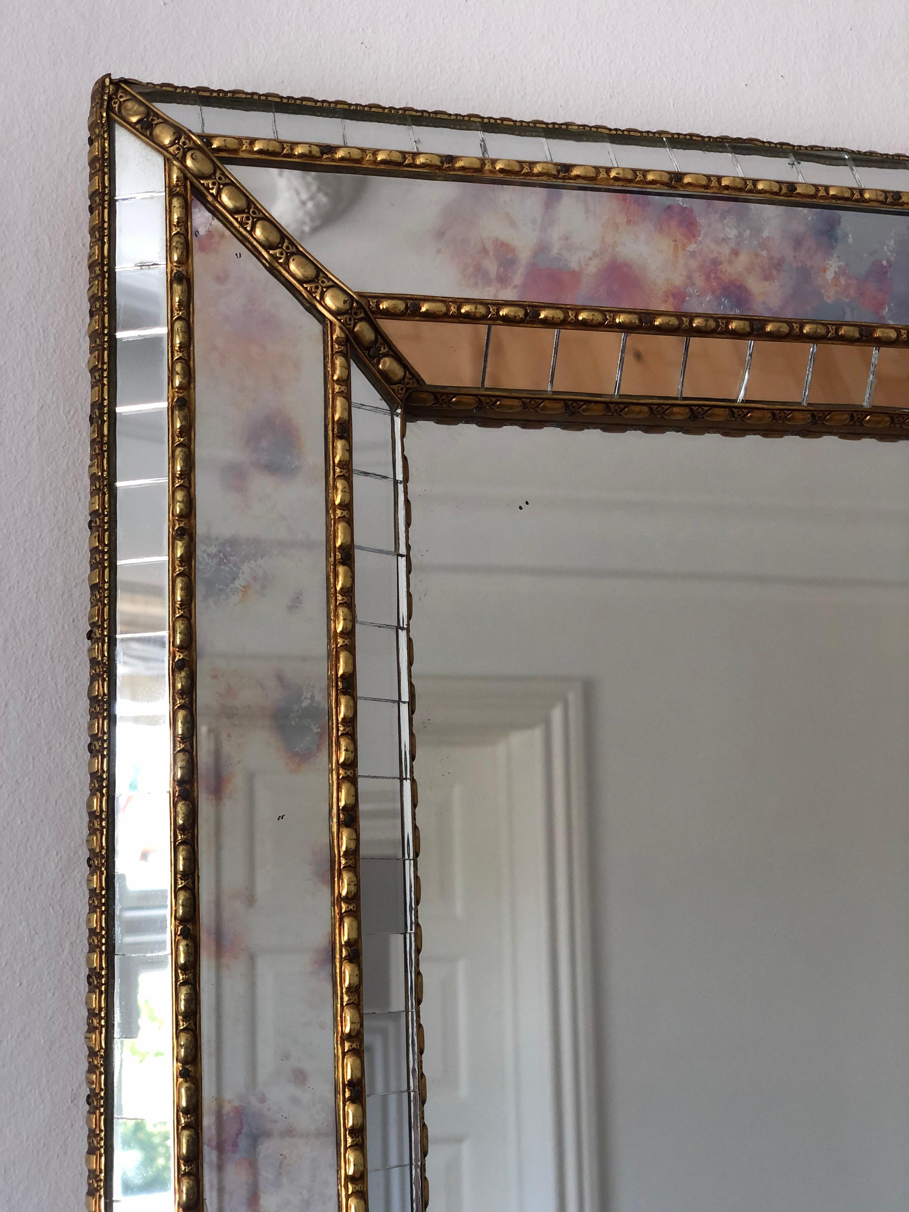 Grande specchio smussato veneziano vintage in stile spagnolo, risalente agli anni '90.
La cornice in vetro fumé è splendidamente lavorata a mano e decorata con piccoli cristalli sui bordi esterni e interni, con cristalli più grandi che corrono lungo