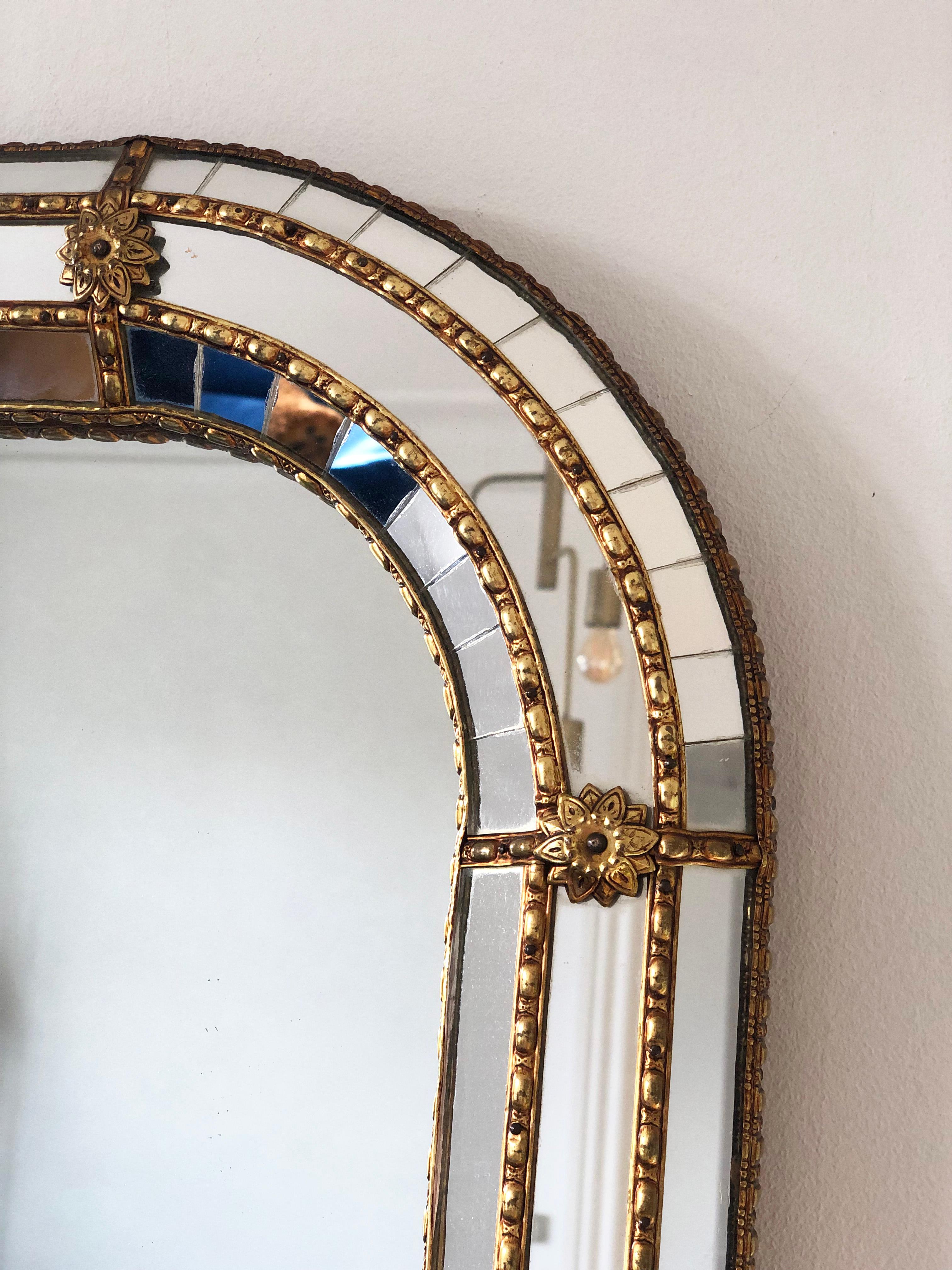 Grande specchio smussato veneziano vintage in stile spagnolo, risalente agli anni '90.
La cornice in vetro è splendidamente lavorata a mano e decorata con piccoli cristalli sui bordi esterni e interni, con cristalli più grandi che corrono lungo il