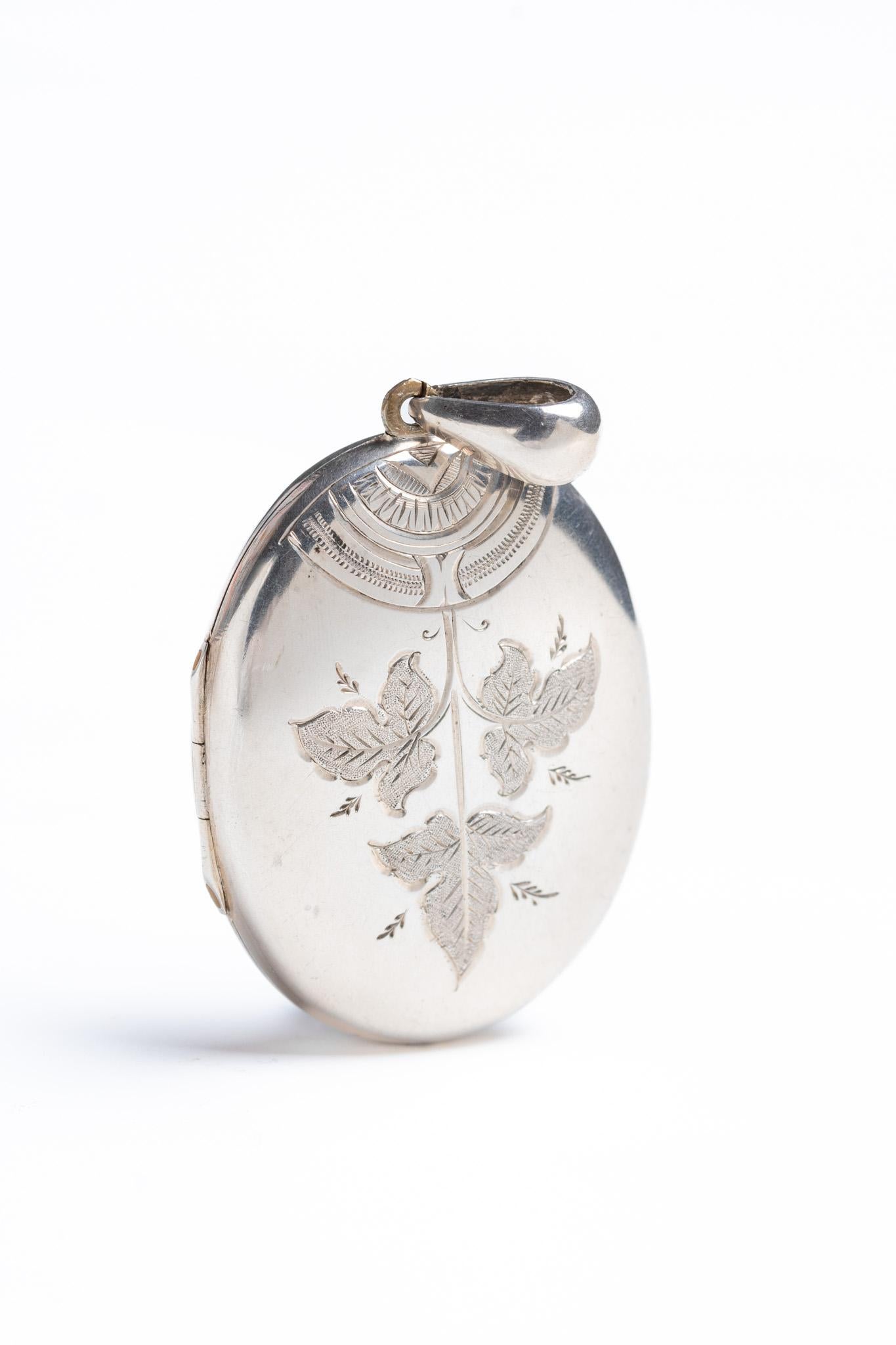 Questo medaglione d'argento vintage in stile vittoriano con disegno di edera risale al 1970 circa e si ispira ai medaglioni in stile vittoriano. Il centro del medaglione è decorato con un grazioso disegno di edera e un motivo geometrico sulla parte