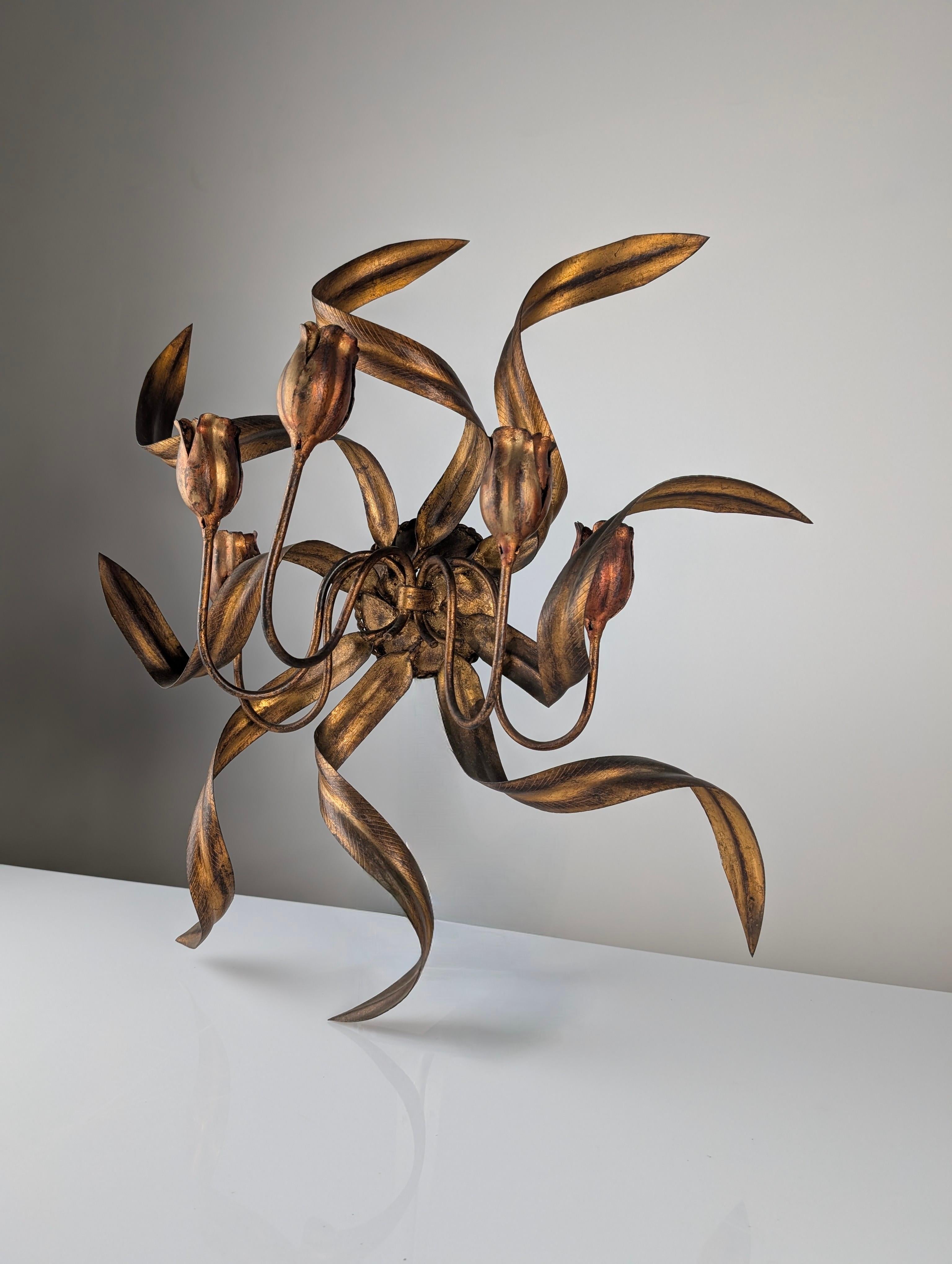 Elegant 1960s wall candelabra crafted in wrought iron with a golden finish, featuring five tulip-shaped candle holders meticulously designed to hold candles and provide warm, decorative lighting.

The tulip leaves intertwine in a circular