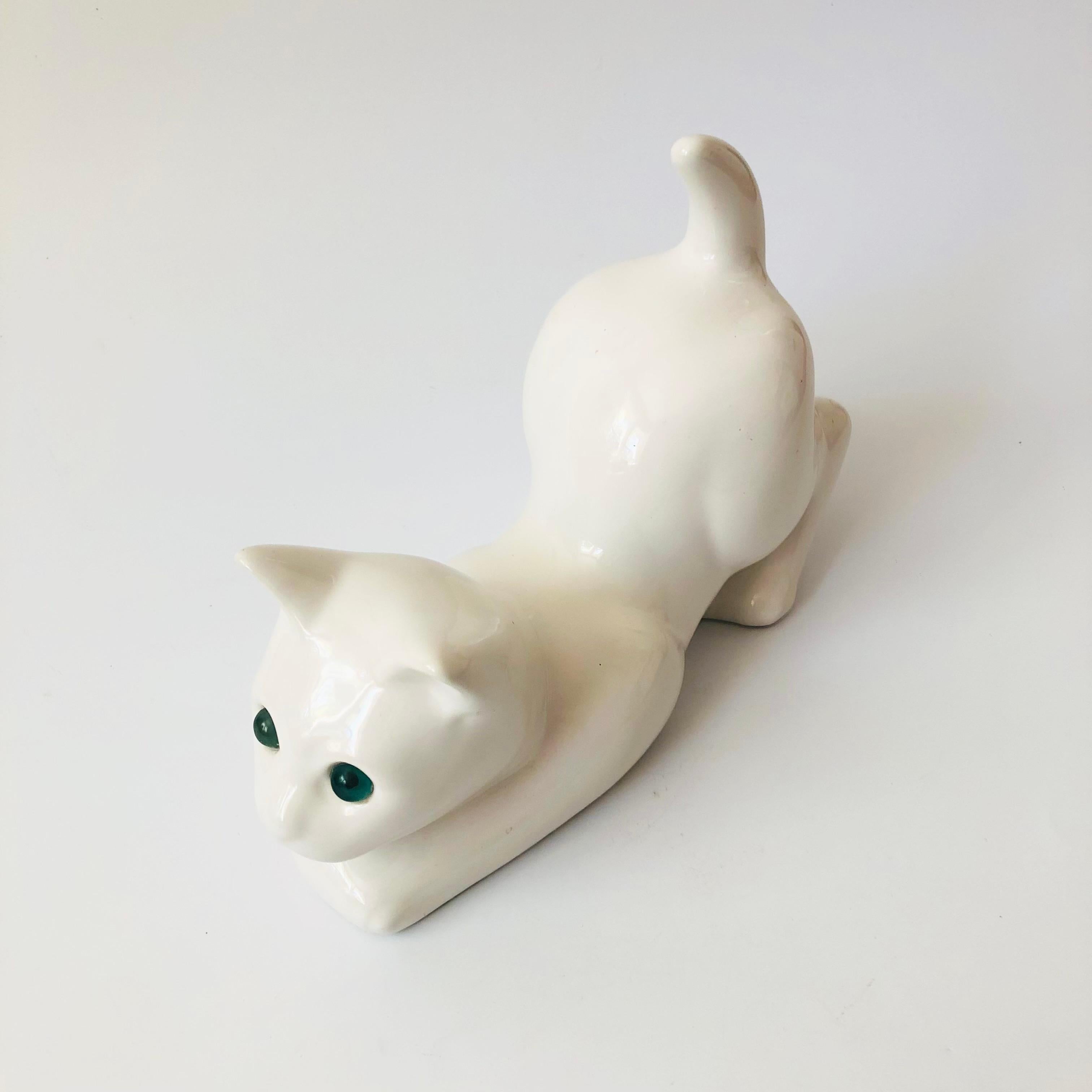 A vintage ceramic cat sculpture finished in a glossy white glaze with blue eyes. Made in Portugal by Elpa Alcobaca, marked on the base.

