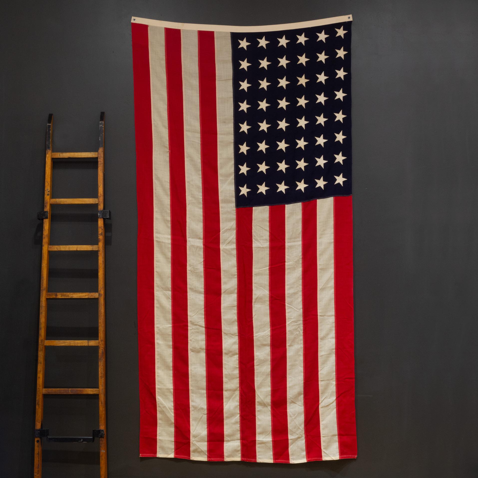 ÜBER

Eine große amerikanische Flagge aus Wolle mit 48 handgenähten Sternen und Streifen. Es ist in gutem Zustand und hat Messingösen zum Aufhängen.

    SCHÖPFER Unbekannt.
    HERSTELLUNGSDATUM ca. 1940-1950.
    MATERIALIEN UND TECHNIKEN Wolle,