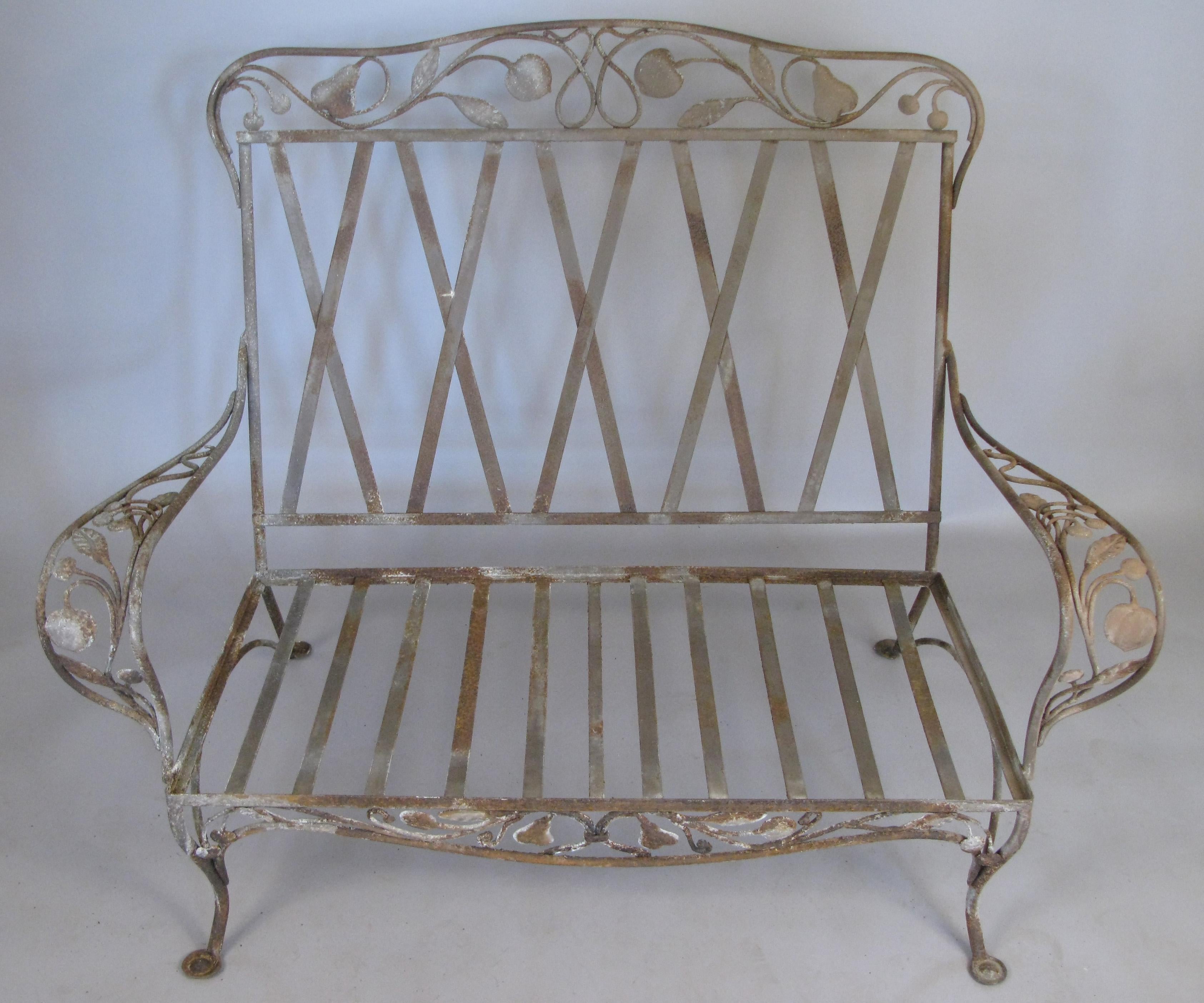A large and rare Saltertini wrought iron settee, with a beautiful decorative motif on the arms, skirt, and seatback of large pears and apples. In original condition, can be stripped and restored if desired.