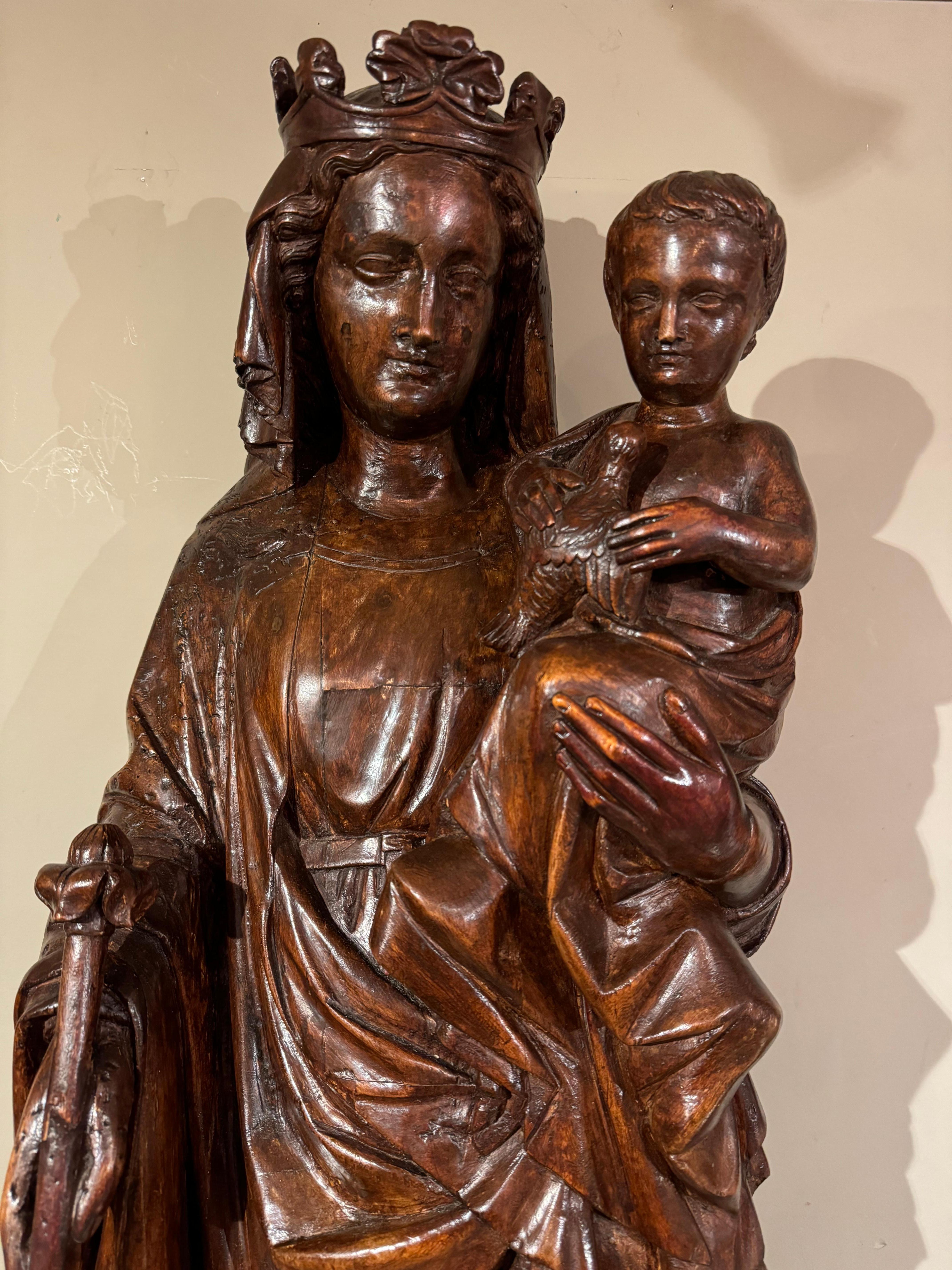  Una Virgen con el Niño muy grande en madera de nogal, tallada en redondo, pisoteando a Eva que muerde la manzana.
El tema de la Virgen y el Niño es el más representado en todo el arte cristiano, mientras que la infancia de Jesús es eludida casi