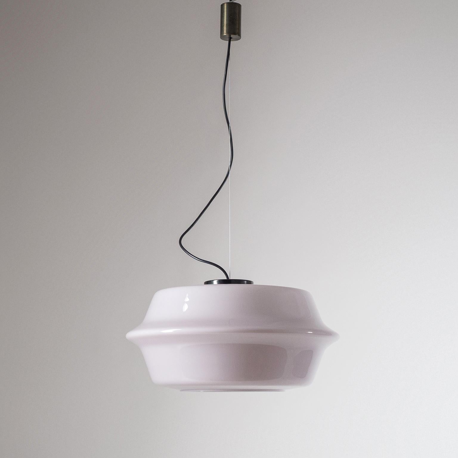 Rare disc-shaped Vistosi pendant with a large, pale Lilac-colored and cased, glass body. Suspended by a steel wire this large hand blown Murano glass pendant appears to hover in place. Canopy and hardware are made of dark patinated brass. One E27