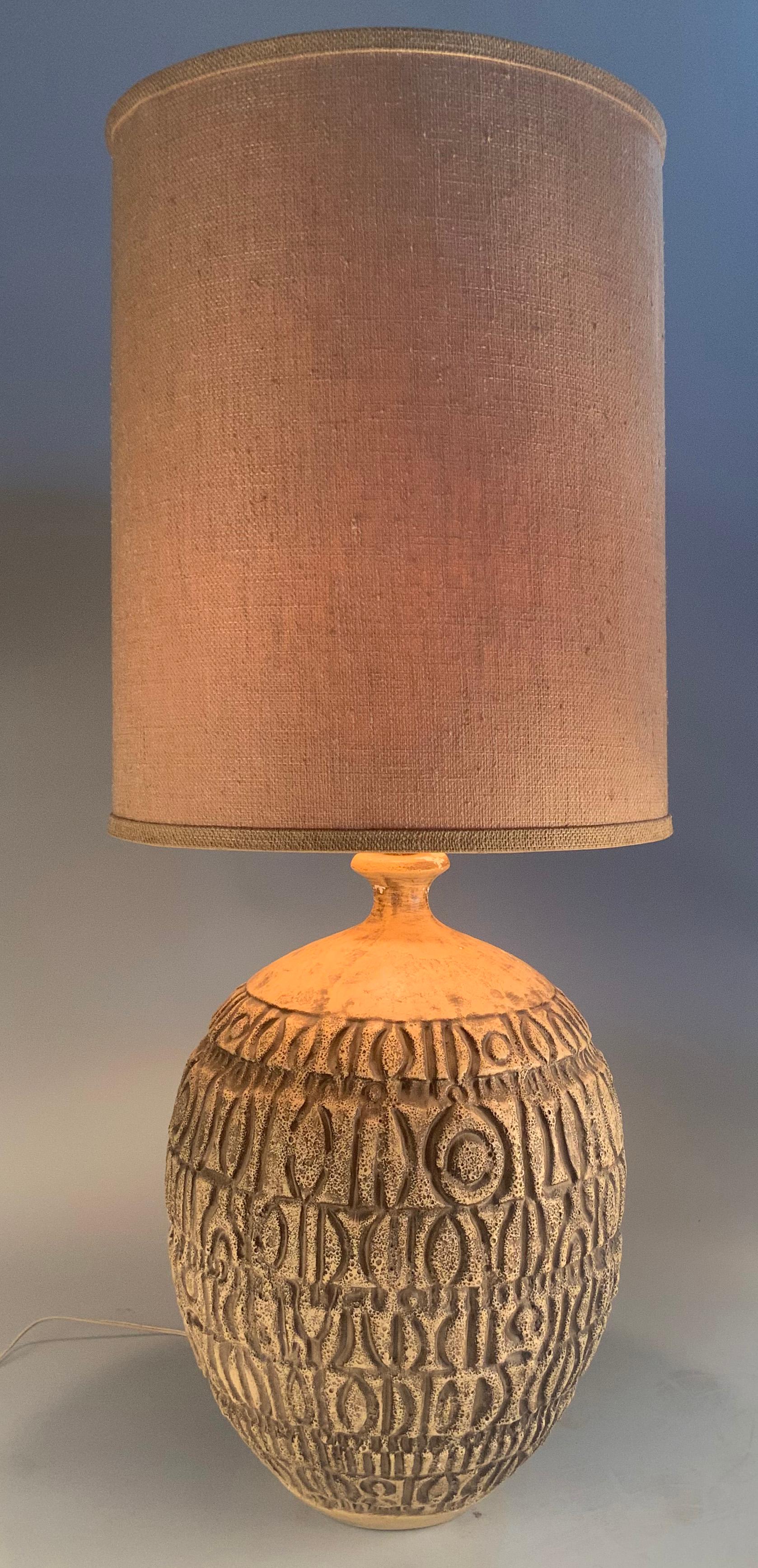 A beautiful large 1950's ceramic lamp with a light beige heavily textured volcanic finish with an abstract geometric pattern. Wonderful scale and proportions. Shade not included.