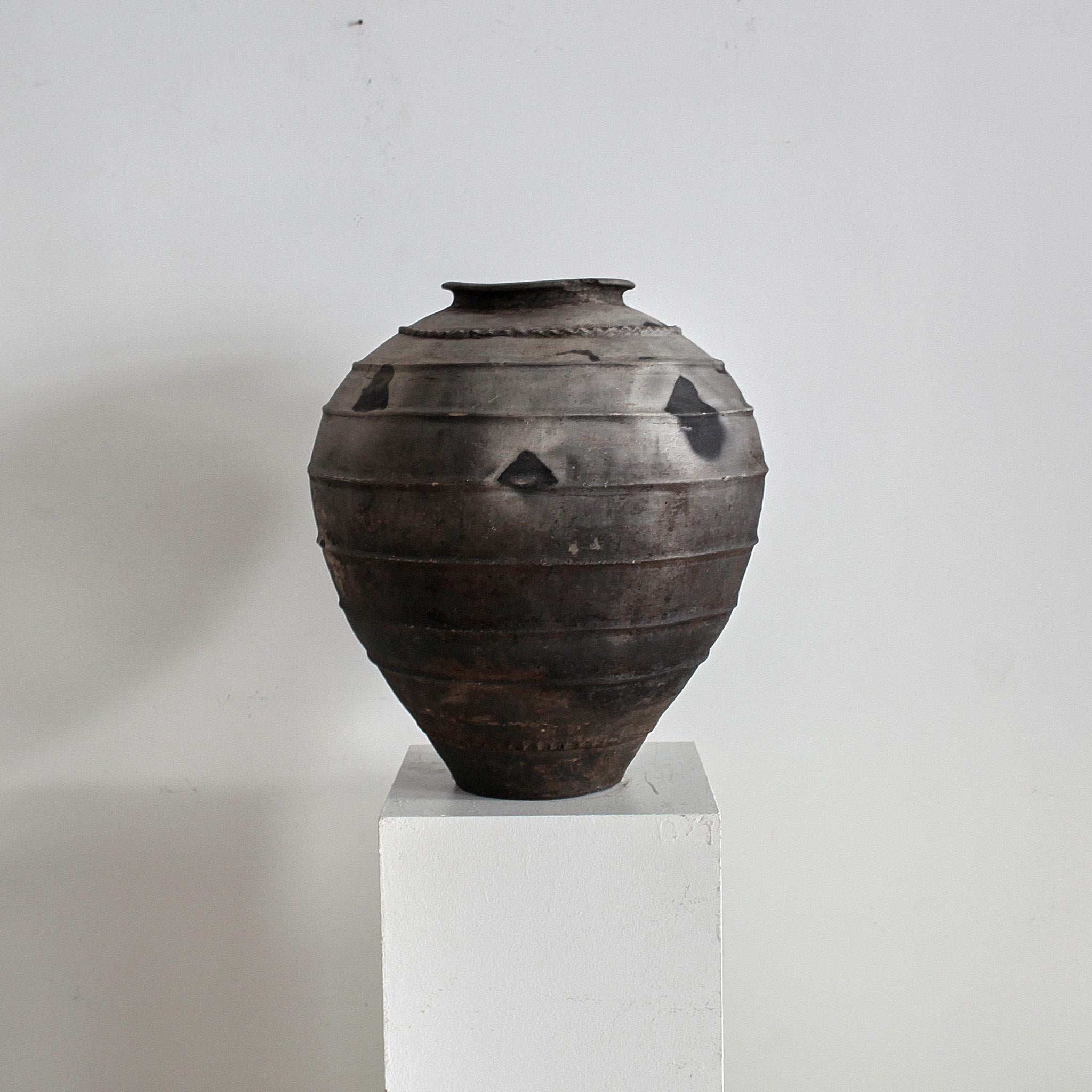 Un vaso di terracotta nera proveniente dal Portogallo settentrionale.

Originariamente veniva utilizzato per conservare l'olio o il vino.

Fortemente patinato con struttura increspata.

Scheggiature storiche sul bordo.
