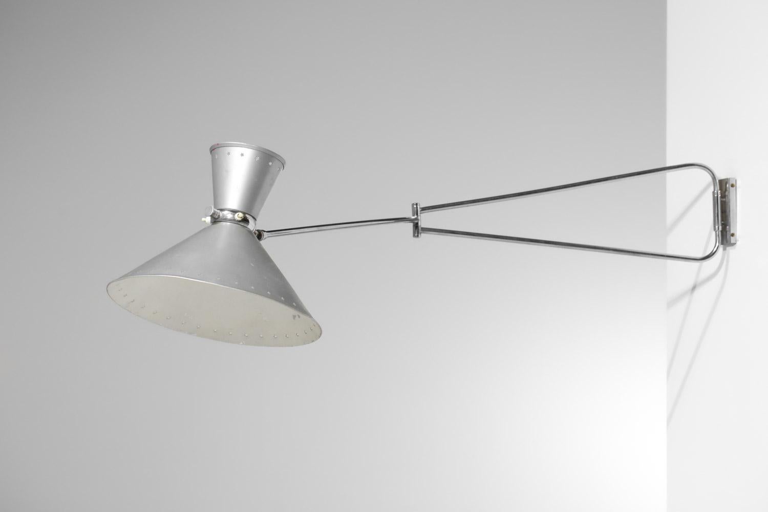 French articulated wall lamp edited by Lunel in the 60s. Chromed metal arm, double adjustable lampshade gara to the ball joint. Both shades are in grey and white lacquered metal (original paint) and perforated with star patterns. Nice vintage