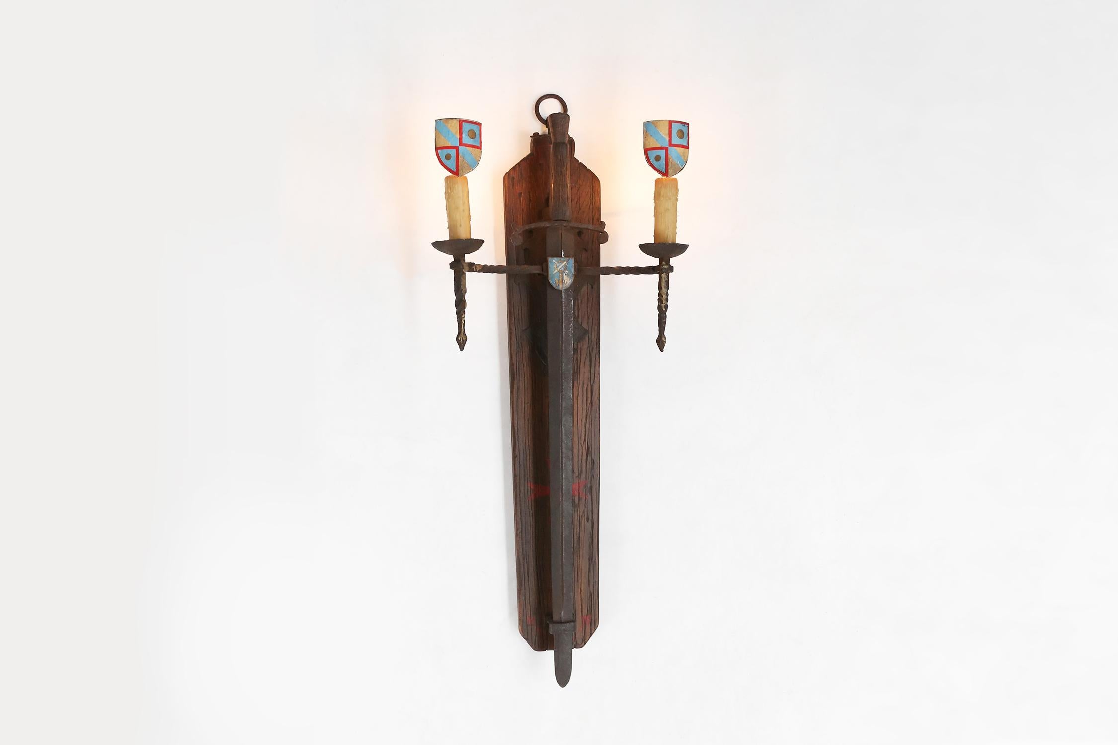 
A large wall lamp with a metal sword in wrought iron is a unique and original choice for a home. This lamp has a beautiful design that creates a medieval atmosphere. The sword is made of metal and can be removed from the lamp if desired. On both