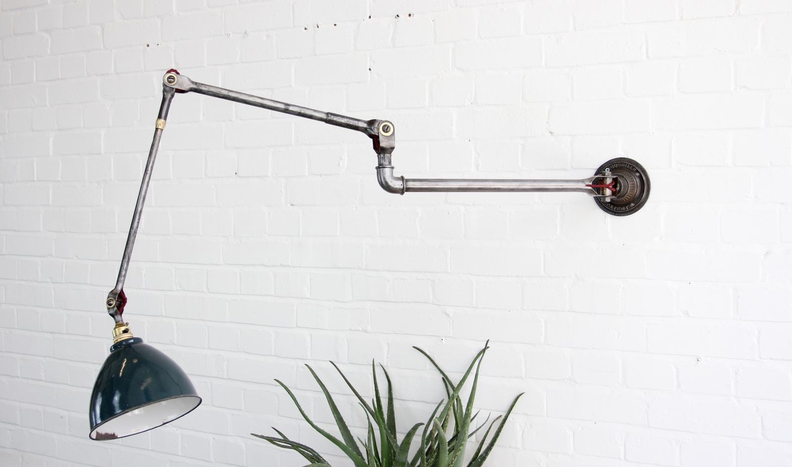 Large wall-mounted industrial task lamp by Dugdills, circa 1920s

- Vitreous green enamel shade
- Brushed steel articulated arms
- Scalloped base with embossed makers mark
- Takes B22 fitting bulbs
- Made by Dugdills
- English, circa 1920s
-