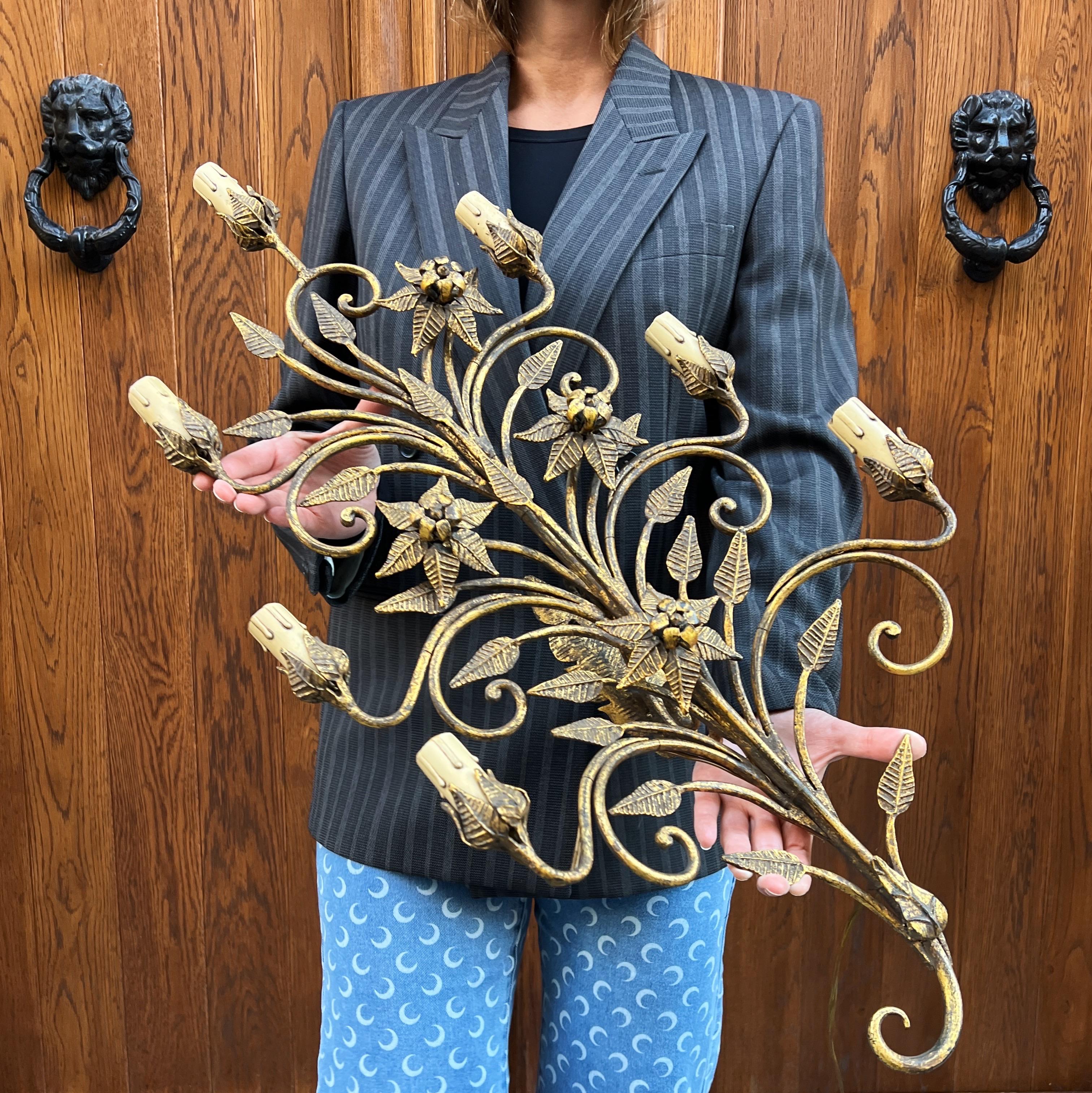 This magnificent gilded iron wall sconce, attributed to Pier Luigi Colli, exemplifies the extraordinary craftsmanship and decorative poetry for which Colli is celebrated. Crafted in the 1950s, the piece features an opulent vertical composition of