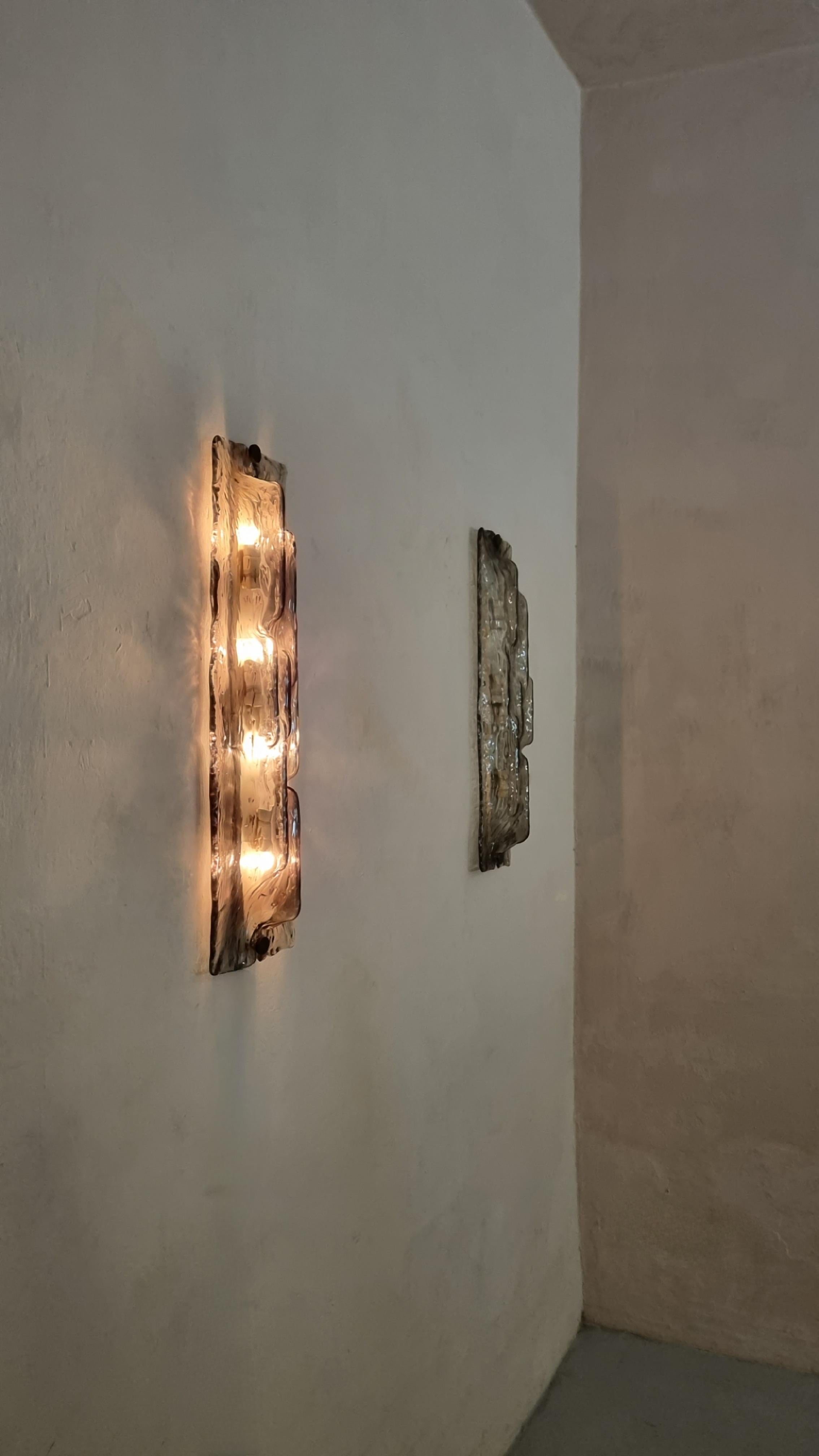 Grandi lampade a parete disegnate da Toni Zuccheri nel 1960 per vetreria Venini. 
Struttura in metallo verniciato e ottone, paralume in  vetro fumè , eccellenti condizioni, 4 punti luce, impianto elettrico revisionato.
Marchio di produzione incusso