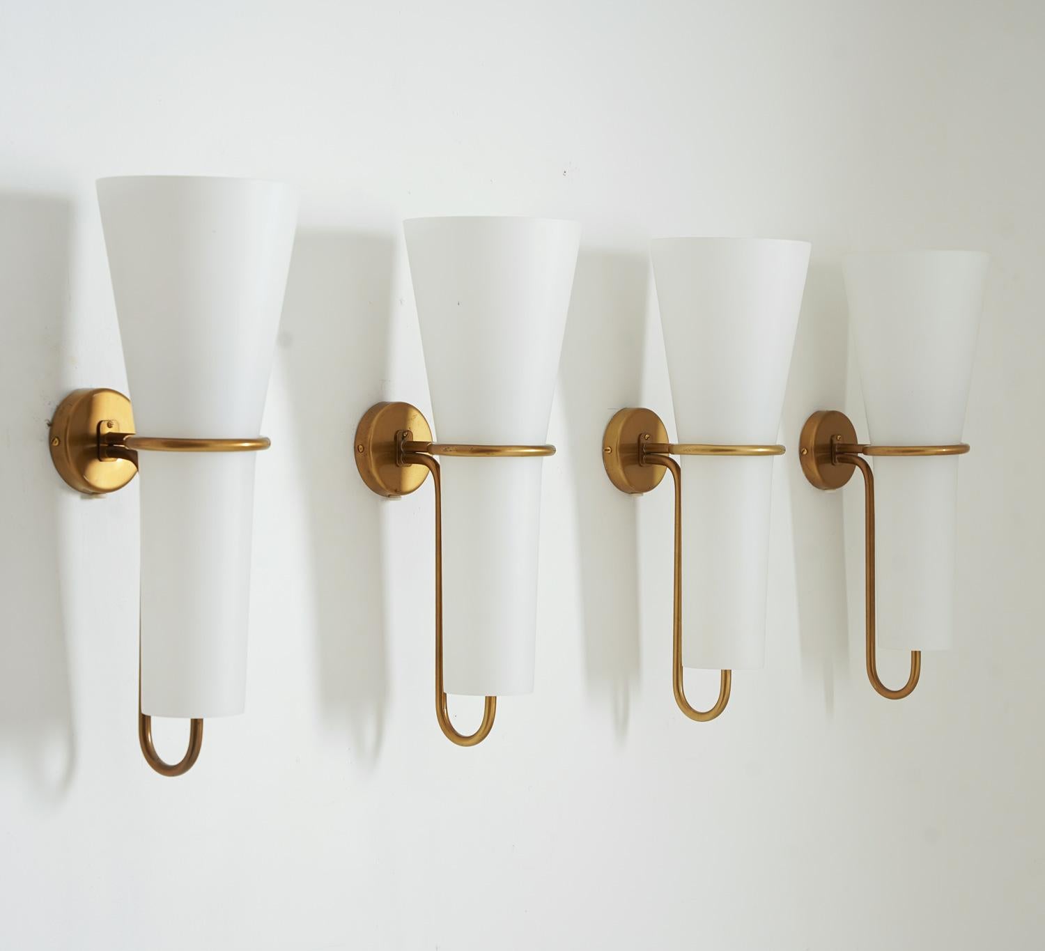 Rare wall sconces by Hans-Agne Jakobsson for Arnold Wiig Fabrikker, Norway. 
These lamps features one light source, hidden by a large opaline glass shade. The shade is held by a brass frame.
Condition: Very good original condition