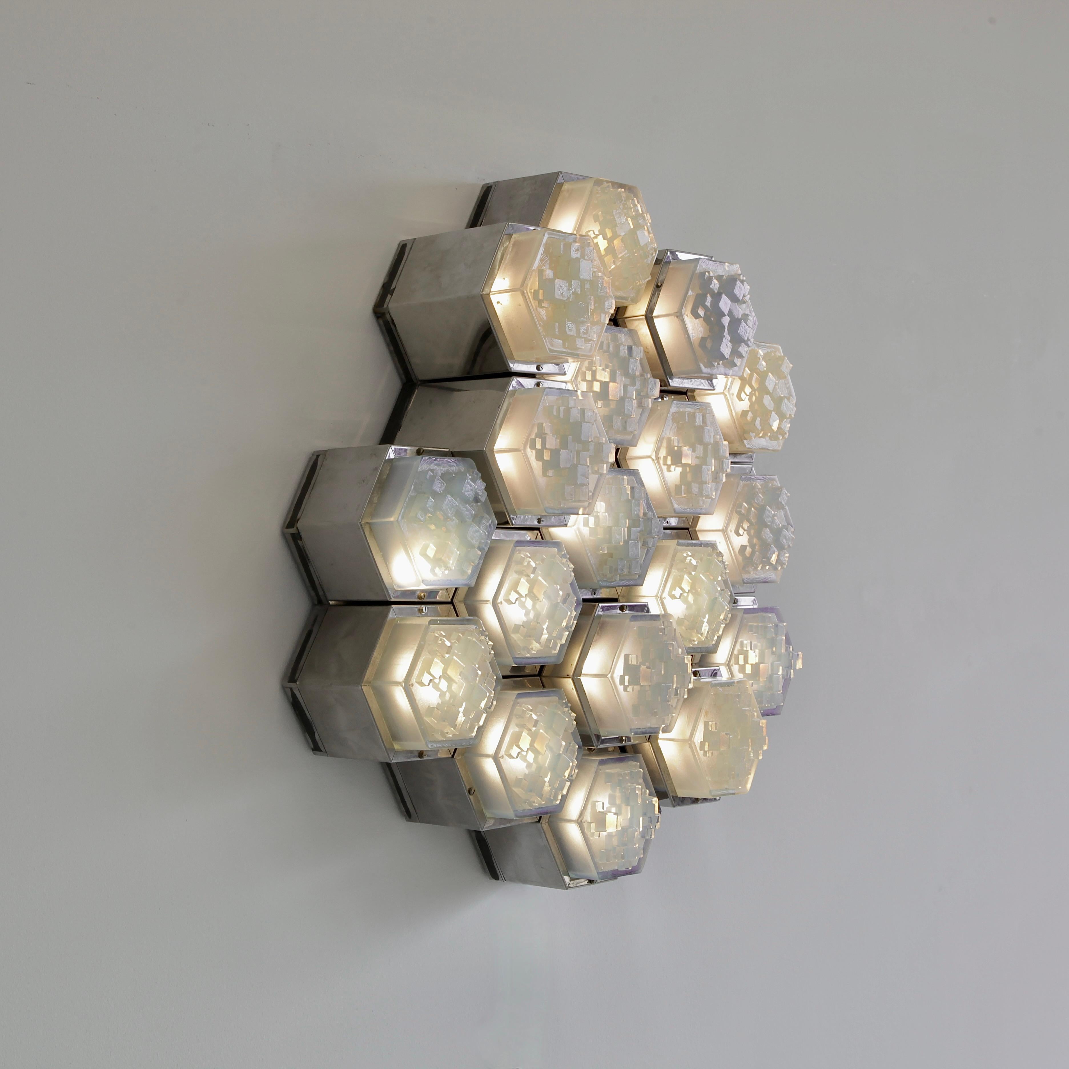 Large wall light designed by Albano Poli. Italy, Poliarte Verona, 1970s.

Large wall lamp/ sculpture using 18 individual light frames with chrome bodies in two different sizes. Inserted are the typical moulded Poliarte glass pieces in light blue