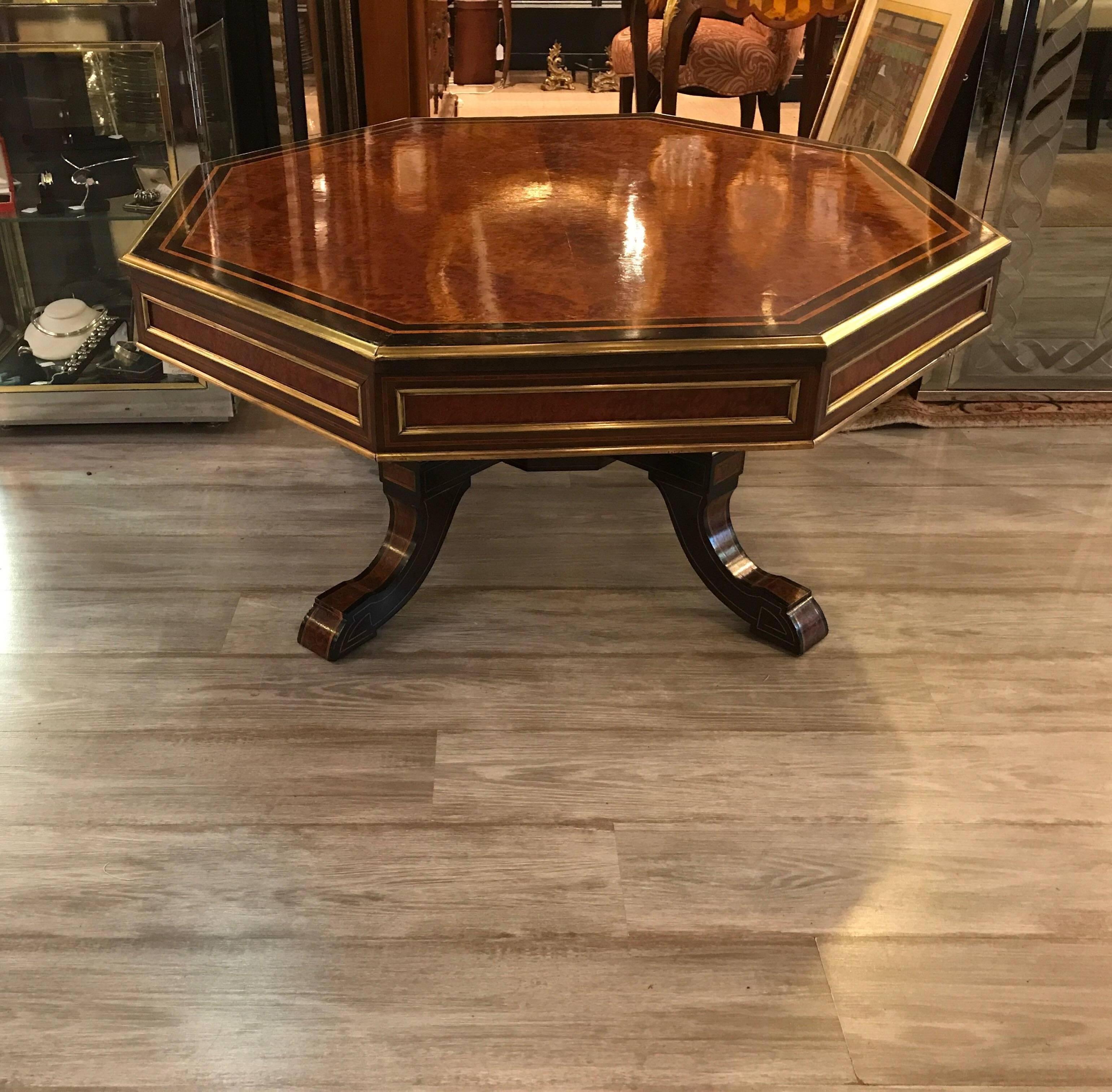 A burl walnut and rosewood hexagonal Napoleon III style coffee table with brass inlay and trim. The large top with burl wood surrounded by rosewood and satinwood. The edges with brass moldings as well as inlaid on the detailed base. Stunning table