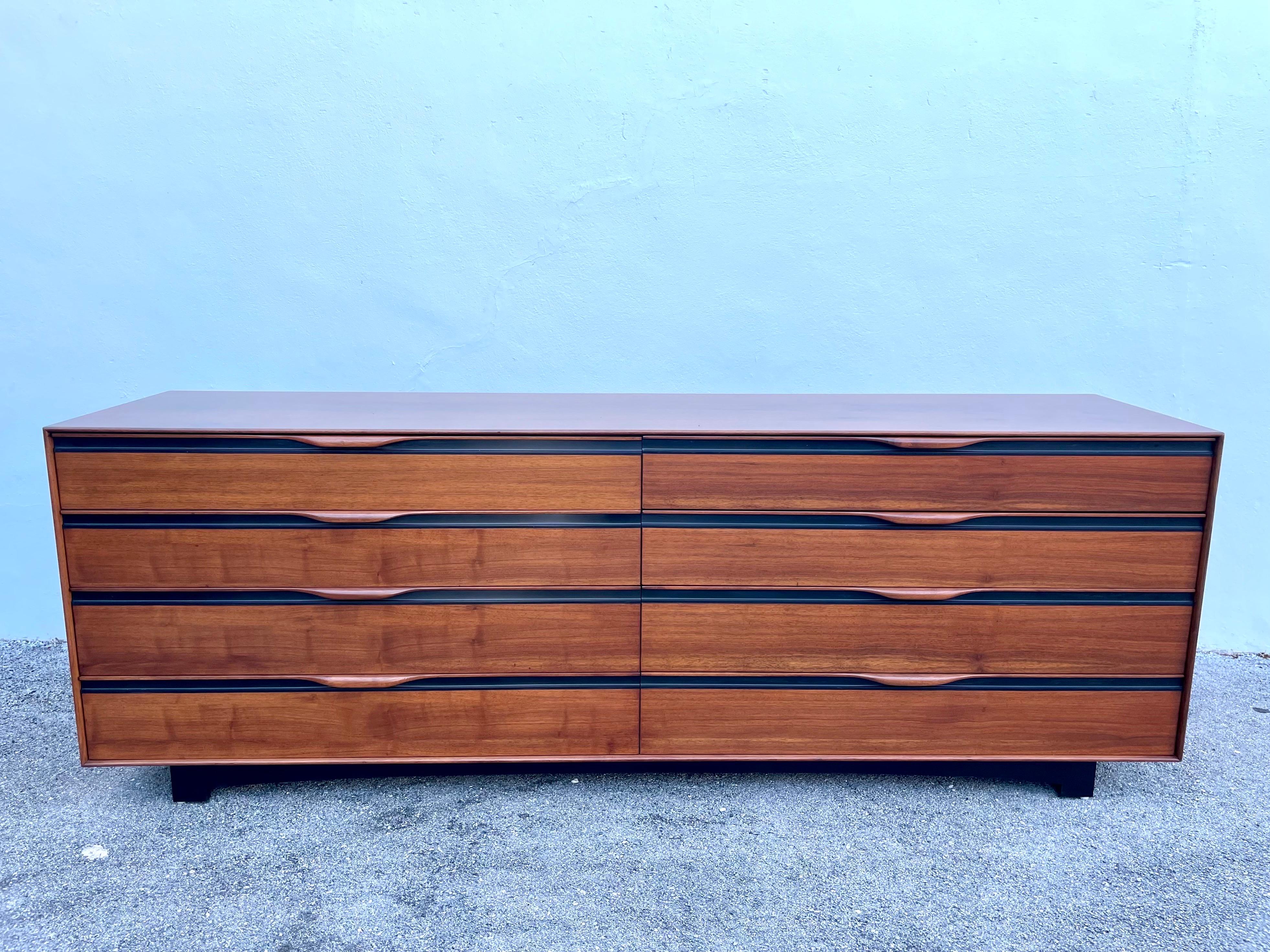 This is an excellent long version of John Kapel's iconic dresser by Glenn of California in walnut and black trim. Eight ample drawers and the drawers slide easily.