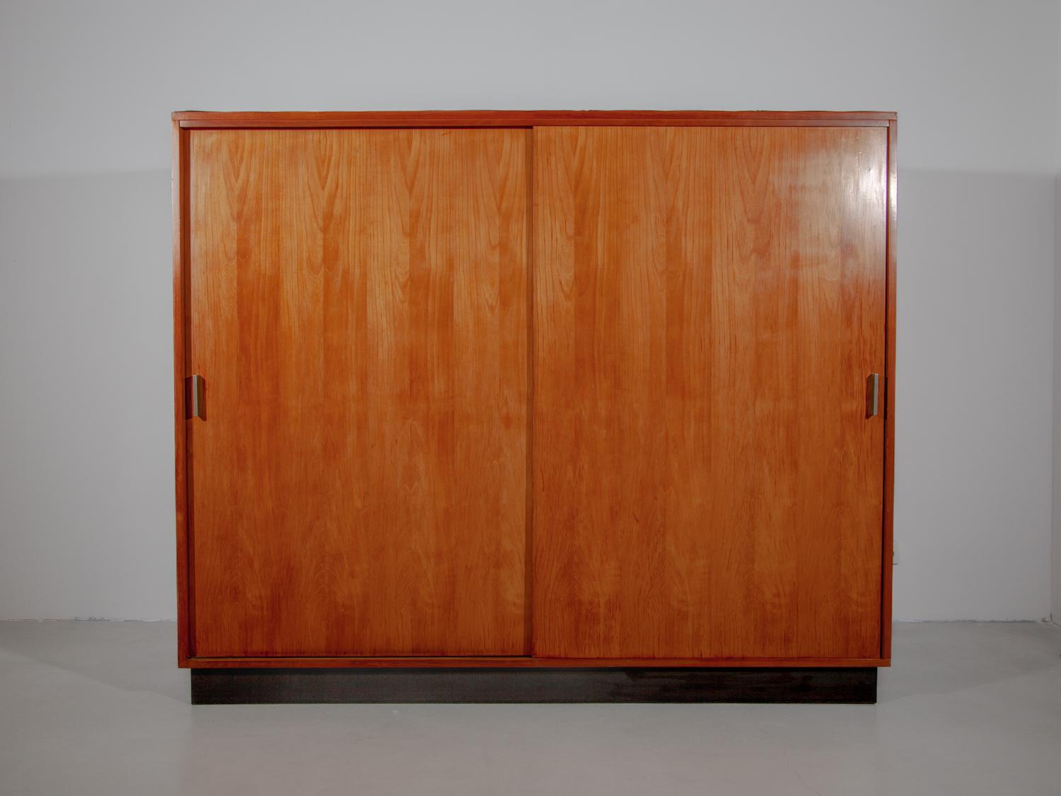 This minimalist wardrobe is designed by the Belgian designer Alfred Hendrickx for Belform. Dating from 1961. This closet features two sliding doors with detailed inlay handles. On the left side a coat hanger and shoe rack. On the right side three