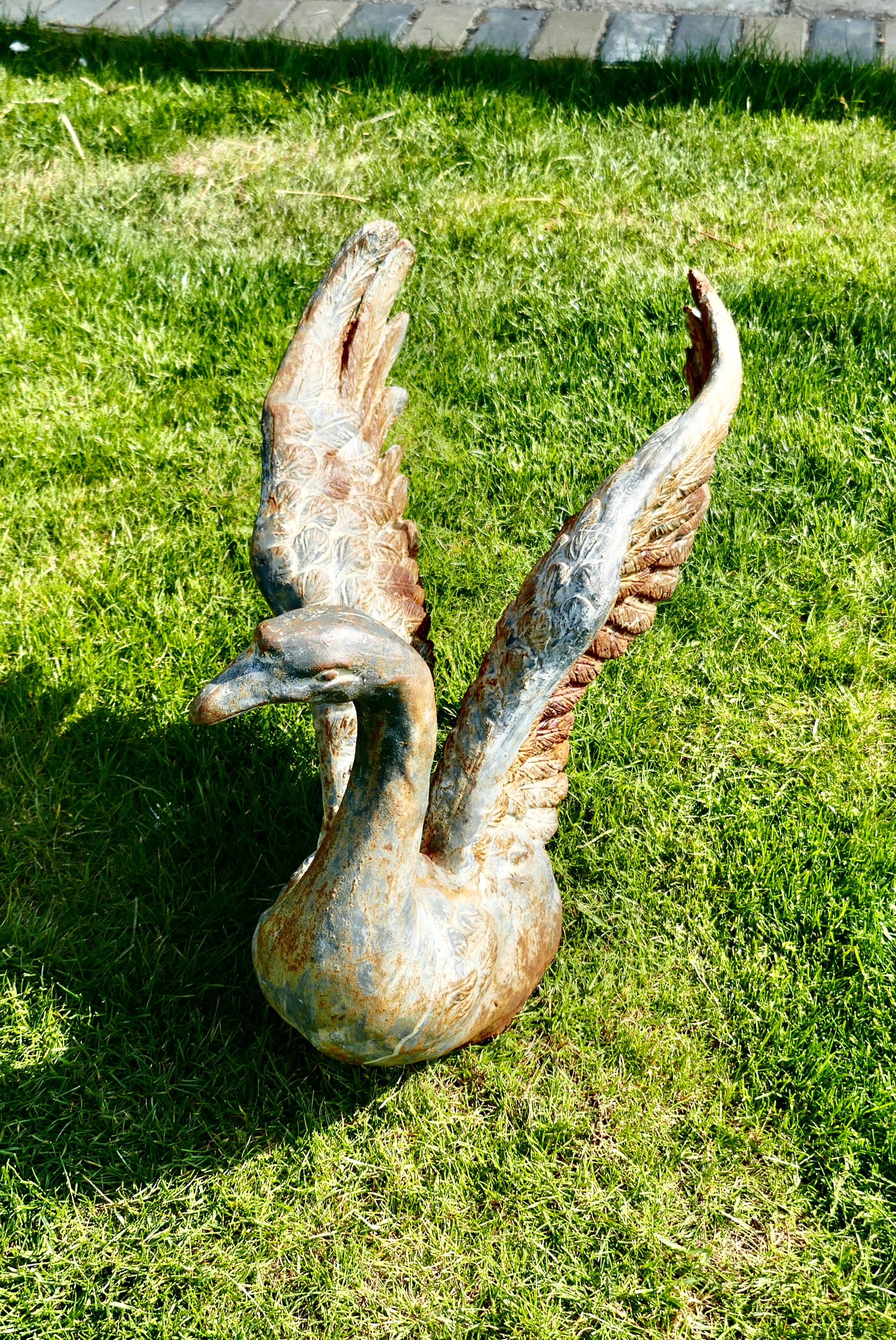 Large weathered cast iron statue of a swan landing

This wonderful statue has a good aged patina it shows a Swan with wings flapping, landing or taking off
This piece has the most superb detailed casting, the feathers and most of all the