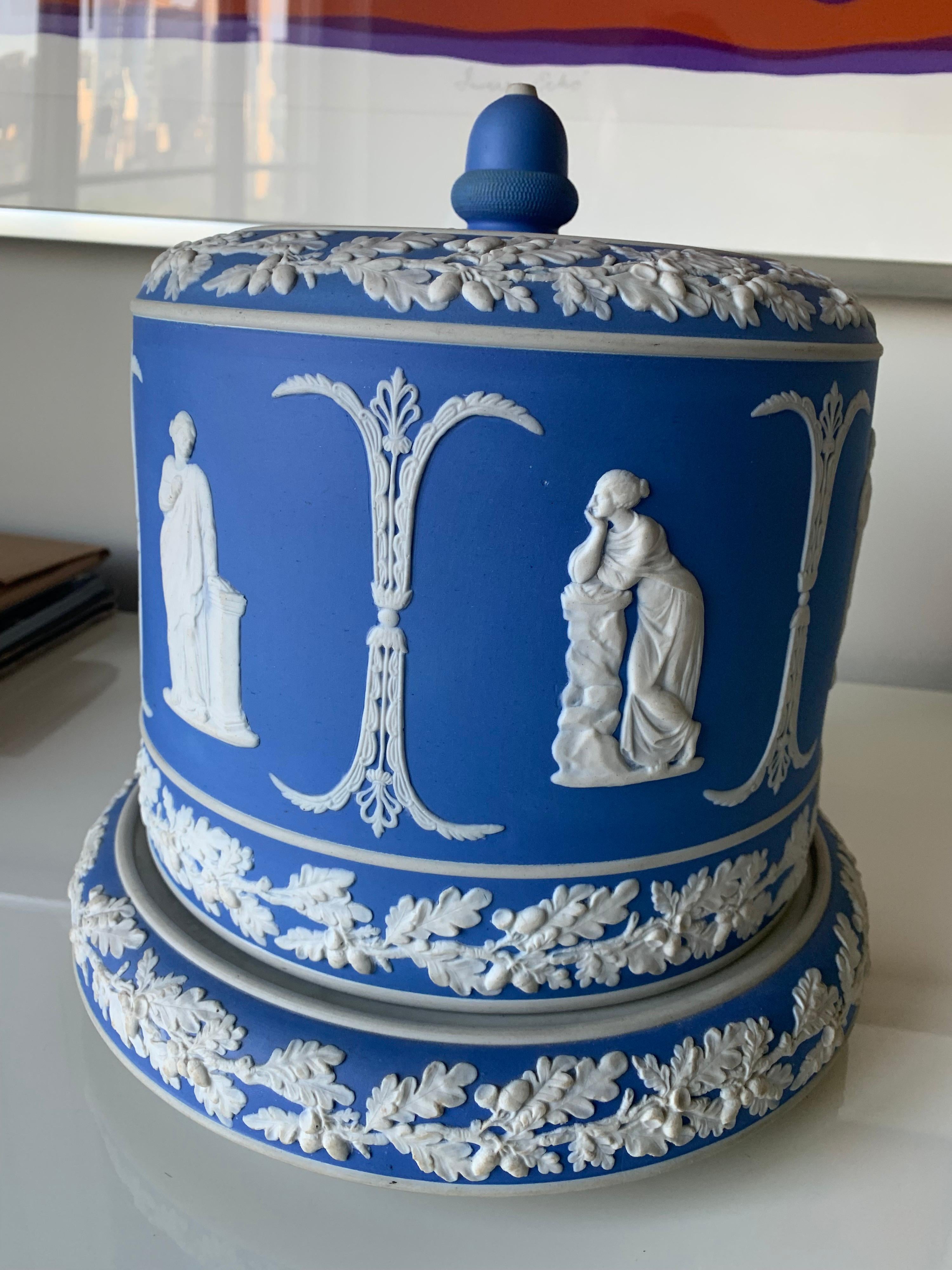 Large light blue jasperware covered cheese dome by Wedgwood. Overall neoclassical motif with acorn border on the under plate. Inside of under plate is marked C, no others makers mark.