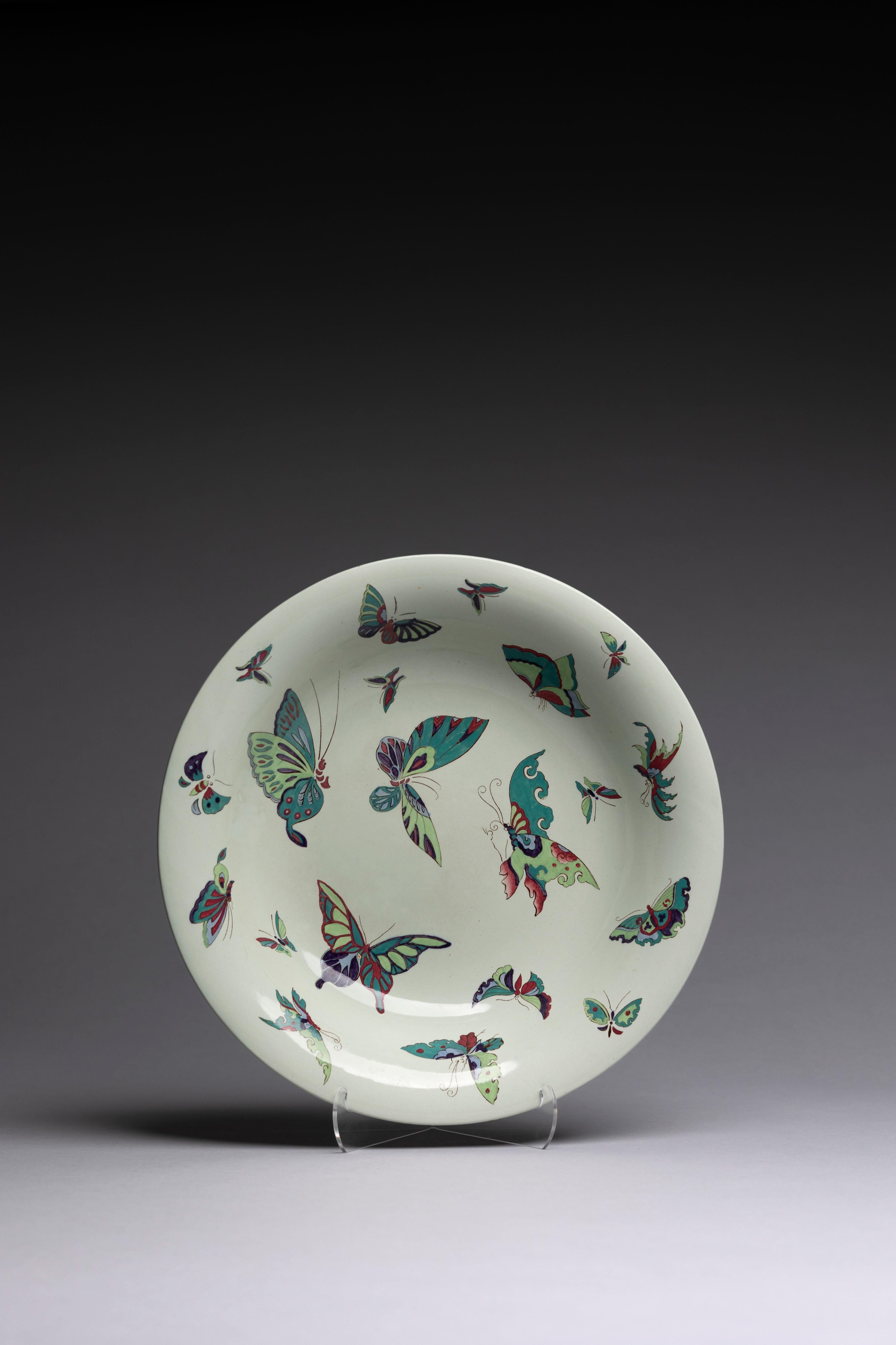Eine große flache Servierschale mit bunten Schmetterlingen, hergestellt von Wedgwood um 1915.

Lebendige Schmetterlinge tanzen um diese Schale und machen sie zu einem auffälligen Schmuckstück. Die einzigartige Farbpalette aus Limettengrün, Petrol,