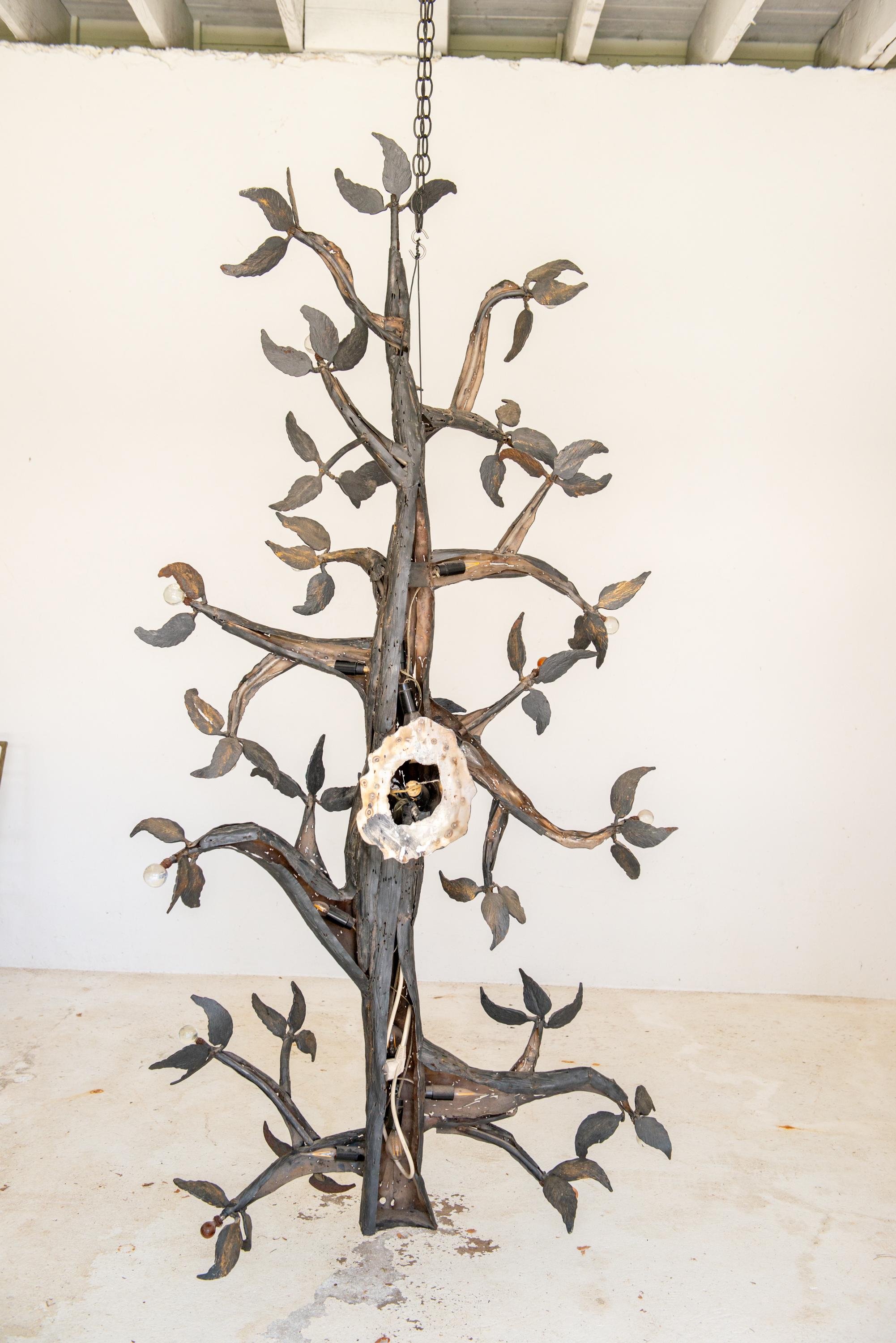 Diese Skulptur ist ein großer geschweißter Metallbaum mit schmiedeeisernem Blattwerk und mit Kristallkugeln verzierten Enden der Äste. Es wird von sechs Glühbirnen hinterleuchtet.
Die Breite beträgt 38