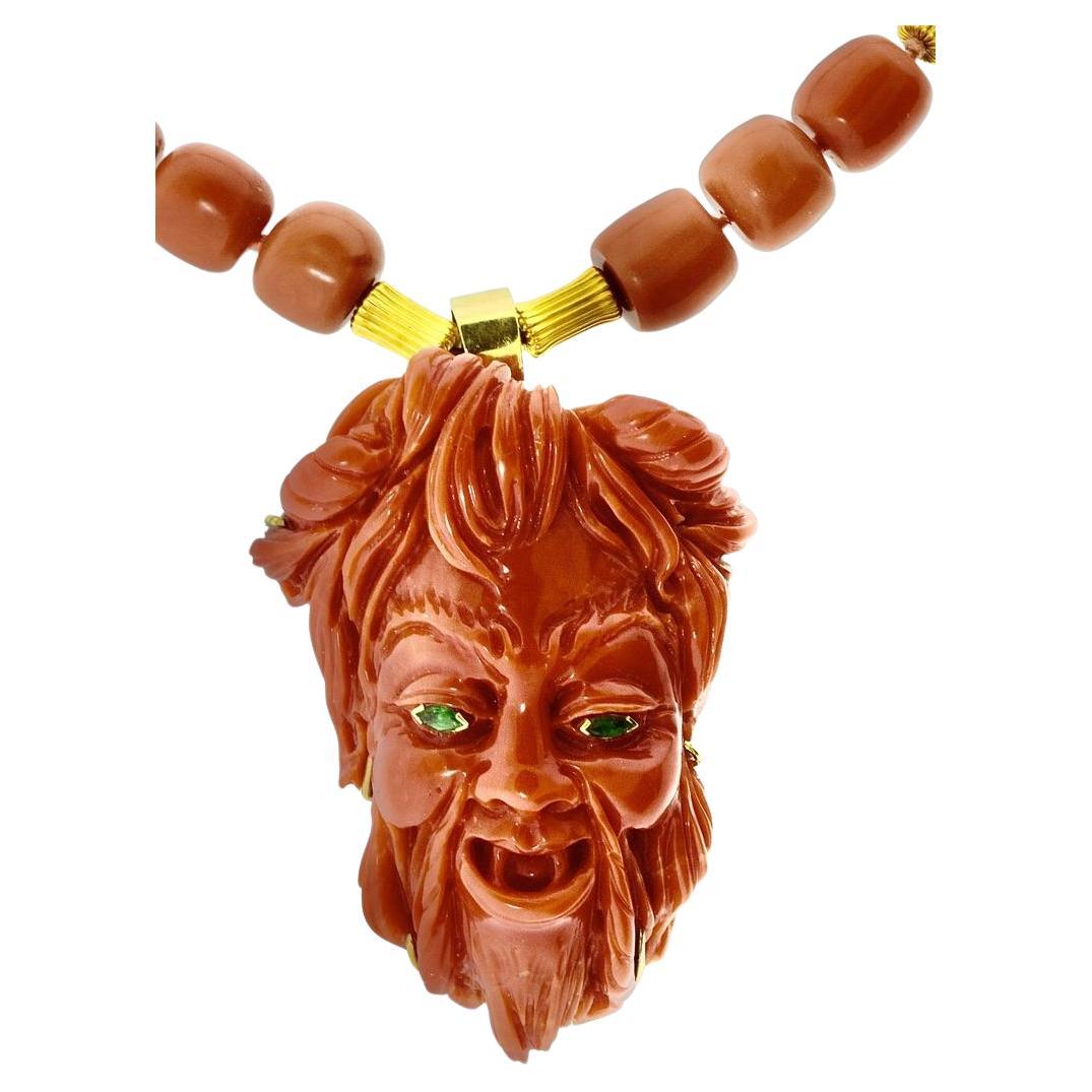 Grande corallo naturale intagliato e tridimensionale, di colore arancione intenso e brillante, raffigurante uno spirito diabolico tanto malizioso quanto maligno. Questo pezzo ben realizzato, dai suoi energici occhi di smeraldo alla sua barba