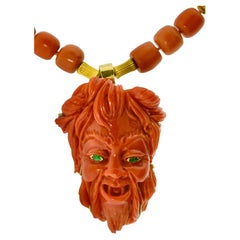 Grande Diavolo felice in corallo ben scolpito con occhi di smeraldo su una collana in oro corallo.