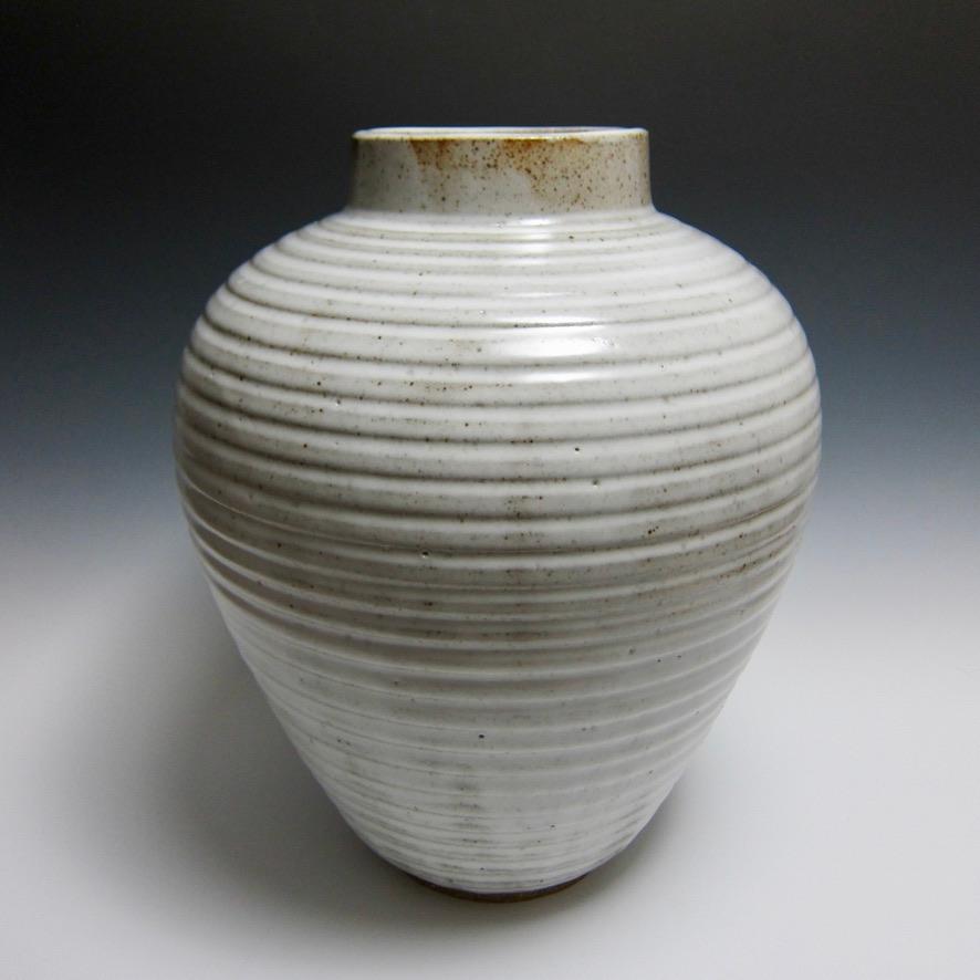 Large wheel thrown textured vase by Jason Fox.

This textured vase was thrown on the wheel in two parts, scored/slipped, joined and then shaped. After letting the clay set up and become leather hard, it was then trimmed, textured and finally the