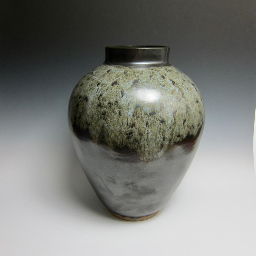 Große radgedrehte Vase von Jason Fox.

Diese handgefertigte Vase wurde in zwei Teilen auf der Drehscheibe gedreht, geritzt/geschliffen, zusammengefügt und dann geformt. Nachdem der Ton ausgehärtet und lederhart geworden war, wurde er