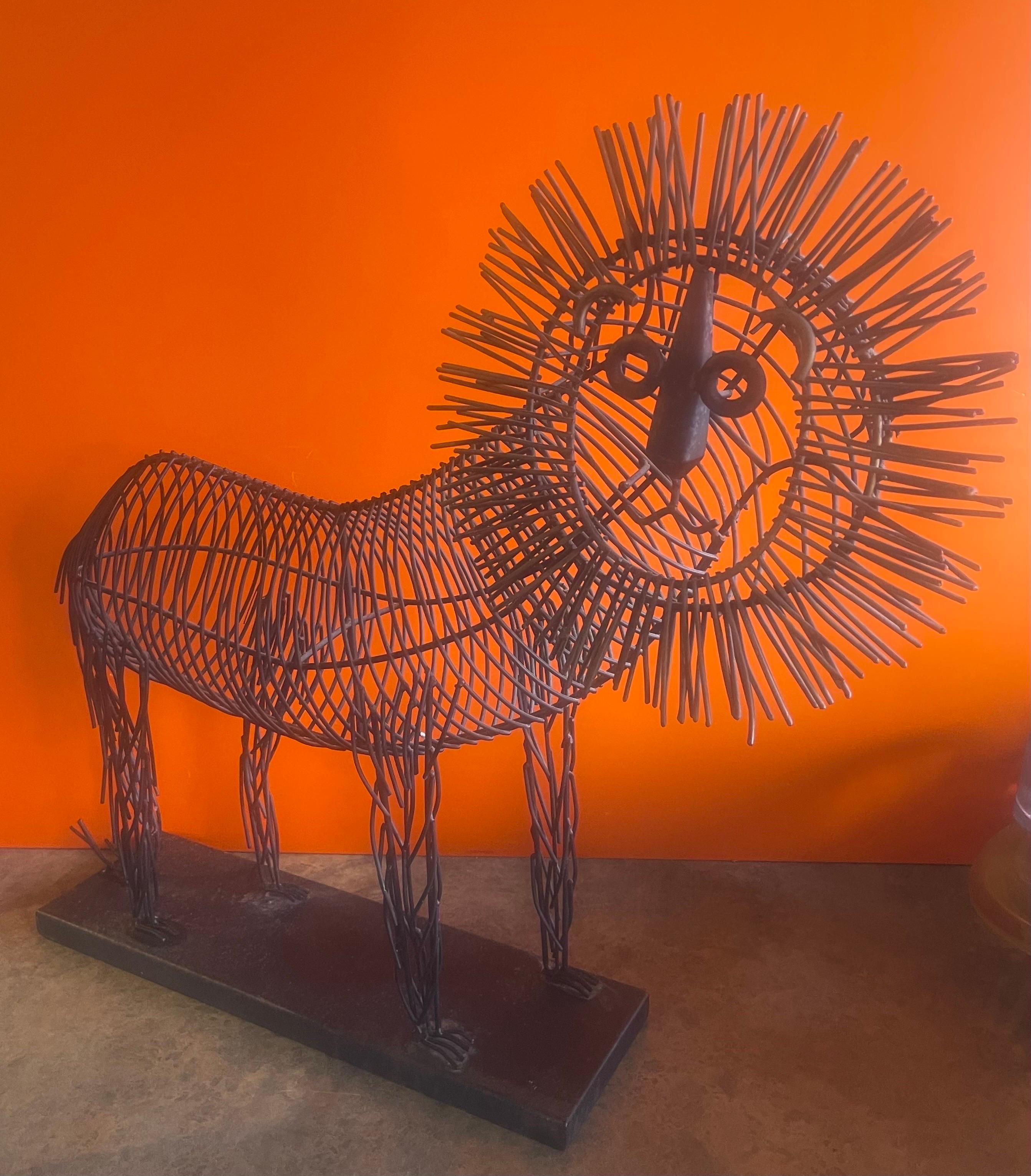 Large whimsical metal wire lion sculpture in the style of C. Jere, circa 1990s. The body is black metal wire and the mane is tinted in gold. The piece is in very good vintage condition and measures 26