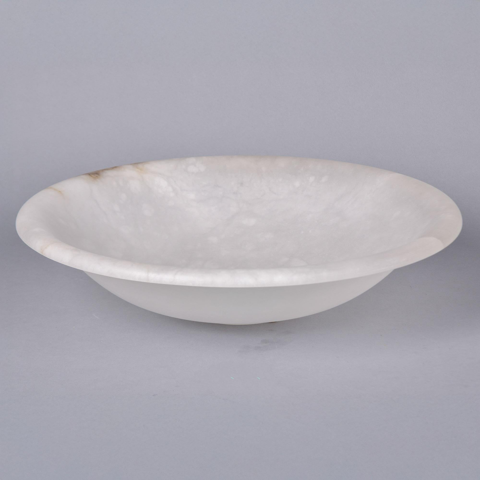  New alabaster bowl found in Italy. Created and designed by a member of a multi-generational family of alabaster and marble craftsman. Creamy white alabaster turned in a classic large bowl form with a small streak of darker alabaster at the outside