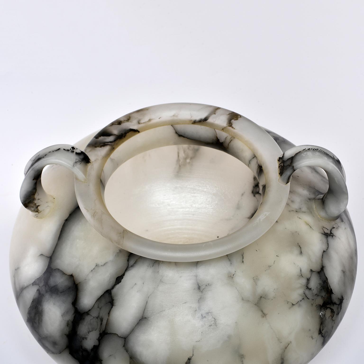 Handmade for us by artisans in Italy, this white alabaster vase features a Classic shape with wide body, narrow neck with handles at the side and rimmed lip. Pale alabaster features dramatic contrasting dark gray veining. New, no flaws found.