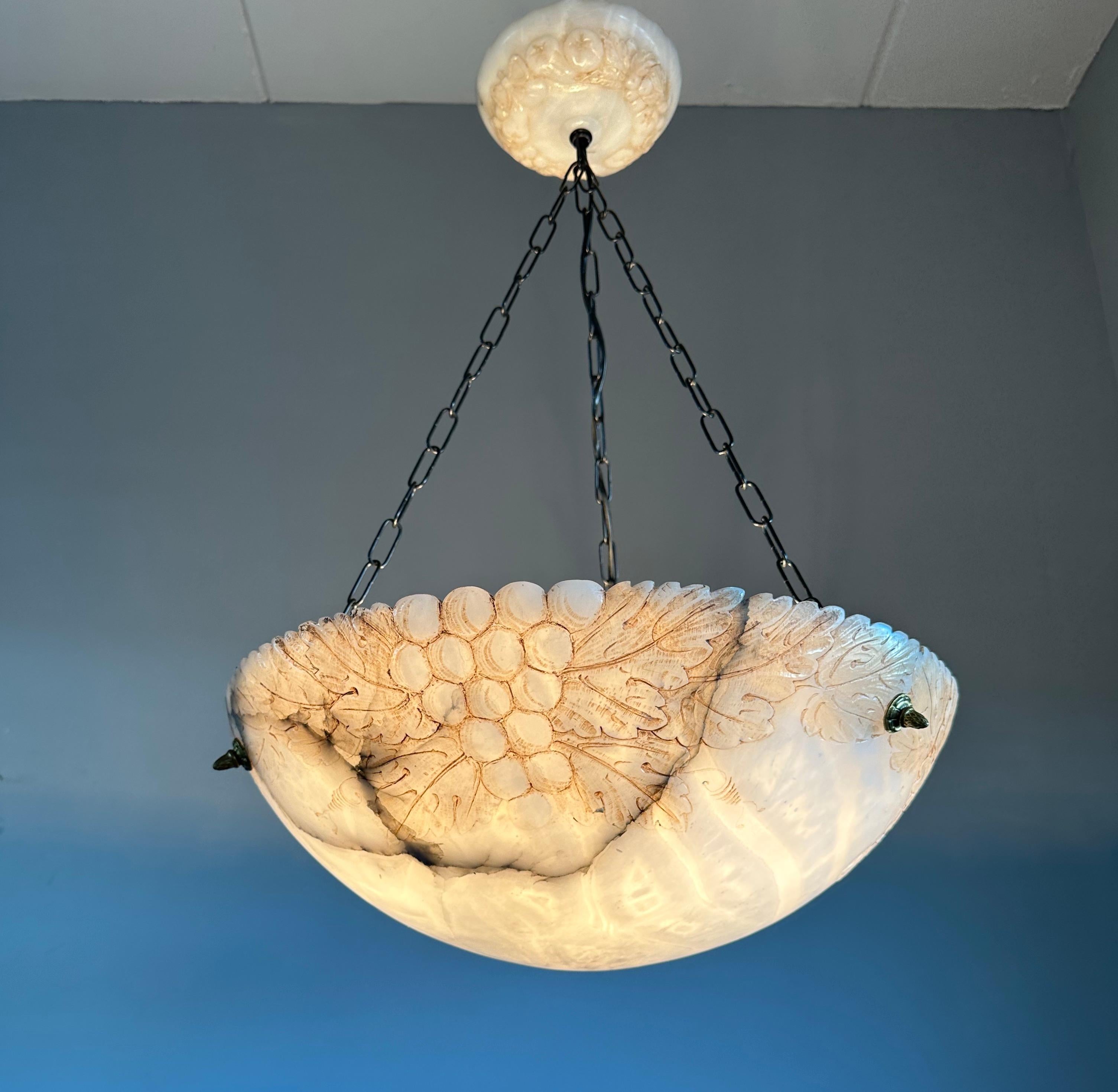 Great antique alabaster chandelier with a hand carved autumn pattern.

This unique Arts and Crafts pendant from the earliest years of the 1900s comes with a wonderful acorn bunch and oak tree leaf design around the upper rim. The pattern is