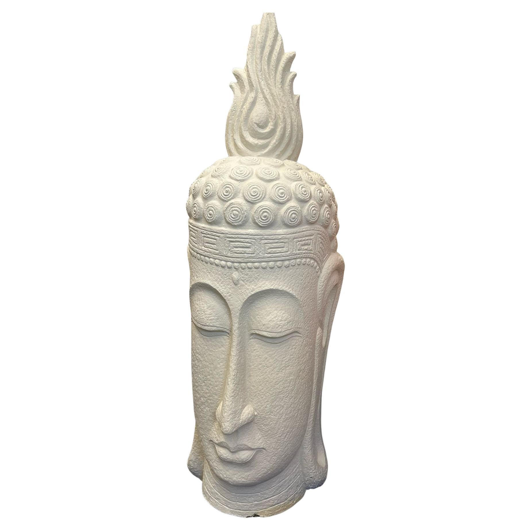 Grandes esculturas blancas de cabezas de Buda sobre peanas