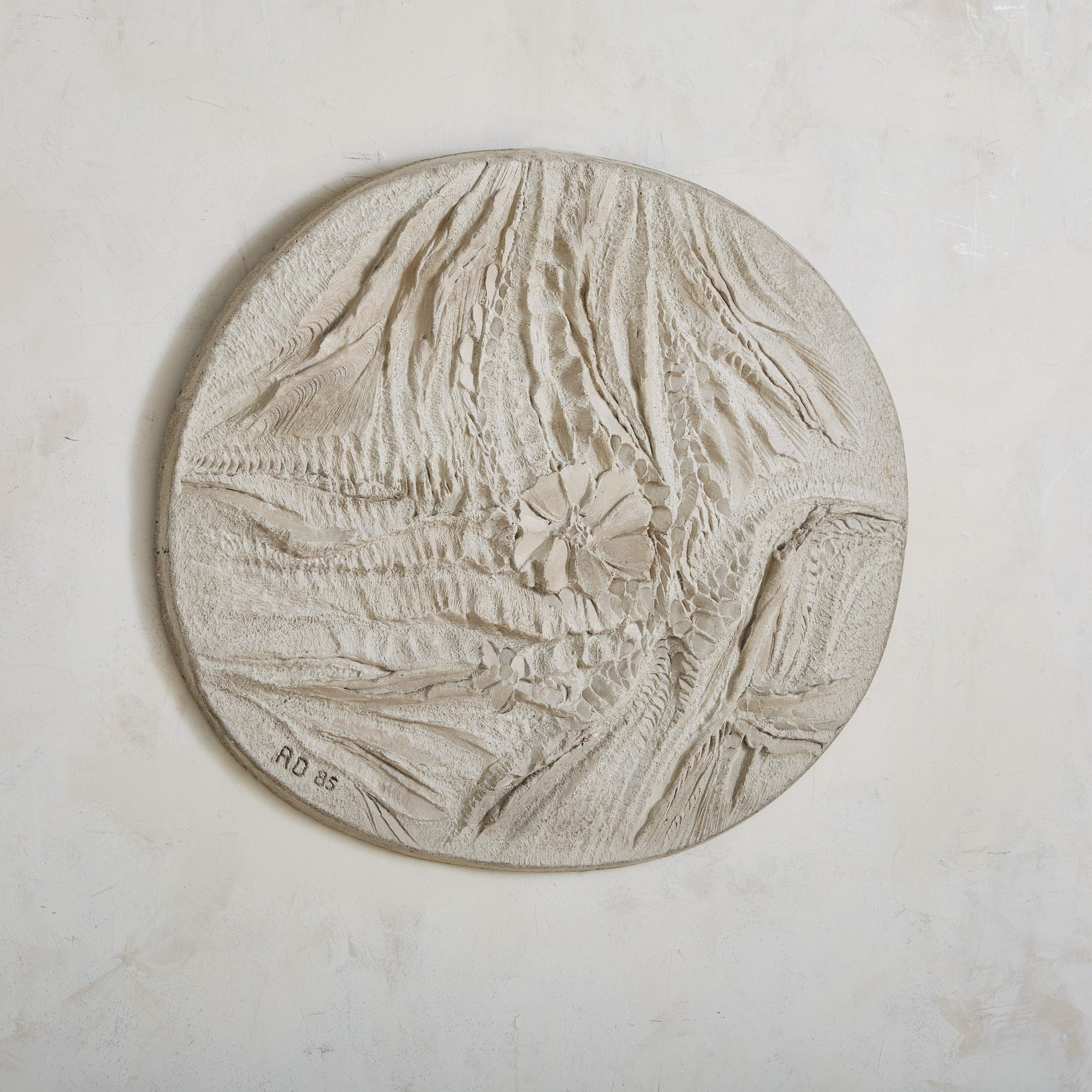 A large oval wall sculpture by French artist Roger Desserprit. This bas-relief, crafted of concrete, has a surface finished in white cement plaster. Abstract floral motifs and intricate texture make it interesting from every angle. Signed and dated