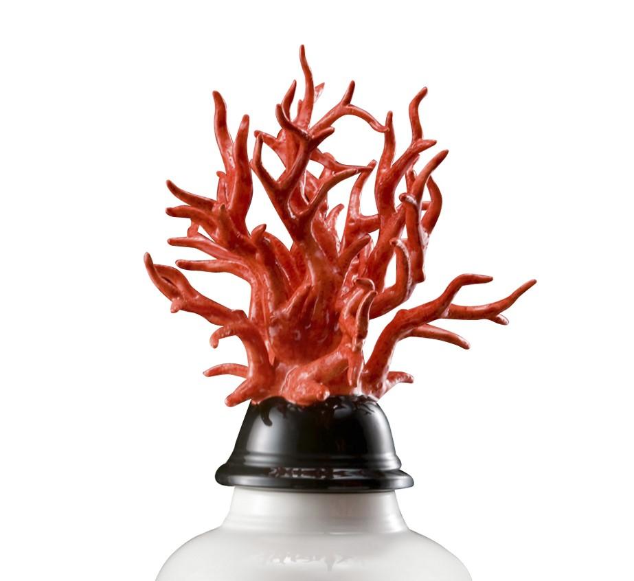 The sinuous shapes of the body of this vase are finished in polished white with a black semi-spherical lid. The lid is adorned with a majestic coral crown, rendered in ceramic with a vivid flame-red finish.