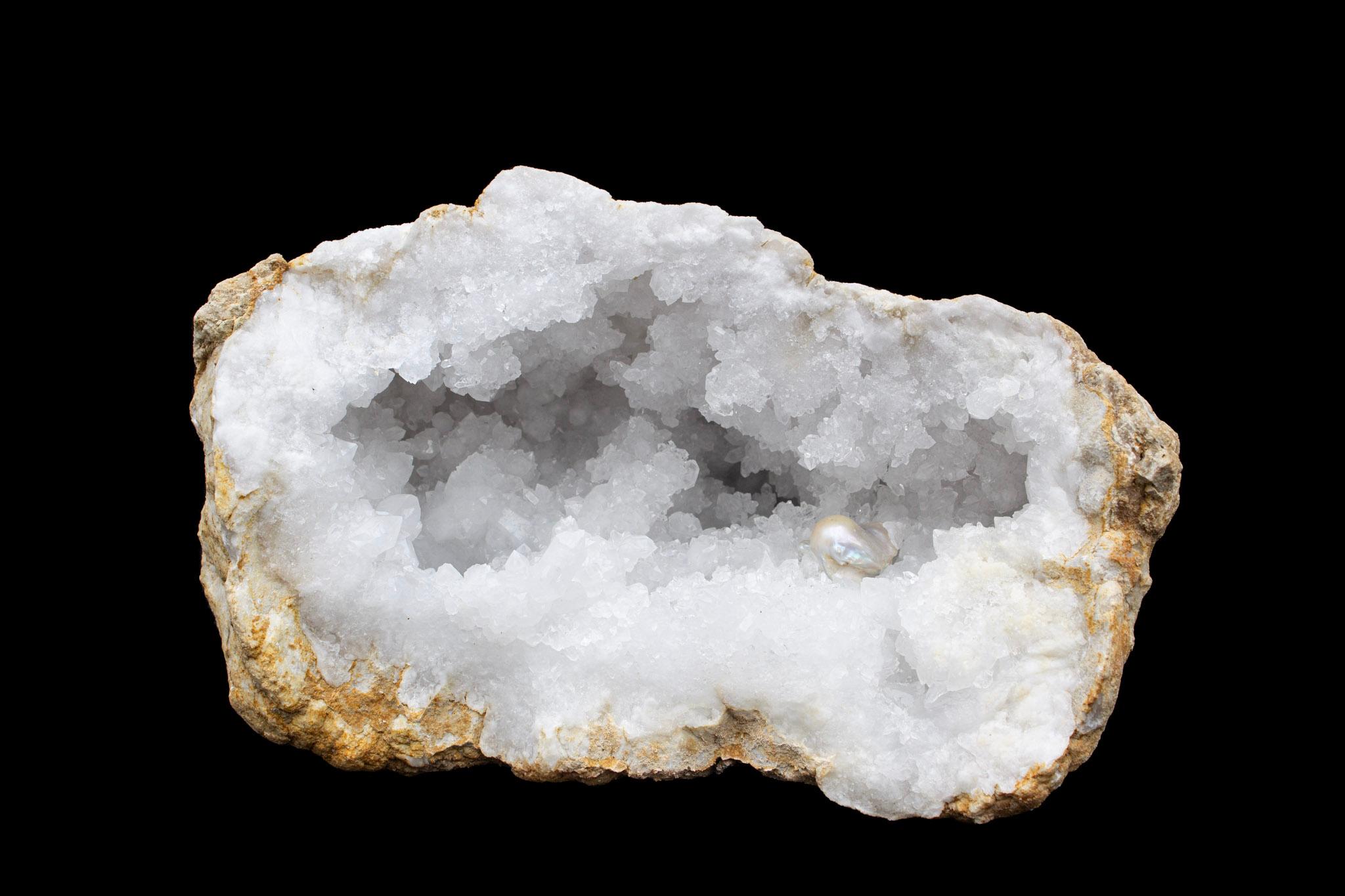 Große weiße Kristallquarz-Geode mit einer großen, natürlich geformten Barockperle. 28 lbs.

Geoden bilden sich als Gasblasen in vulkanischer Lava. Im Laufe der Zeit verwittert der Lavastrom und lässt die Quarzgeode tief in der marokkanischen Wüste