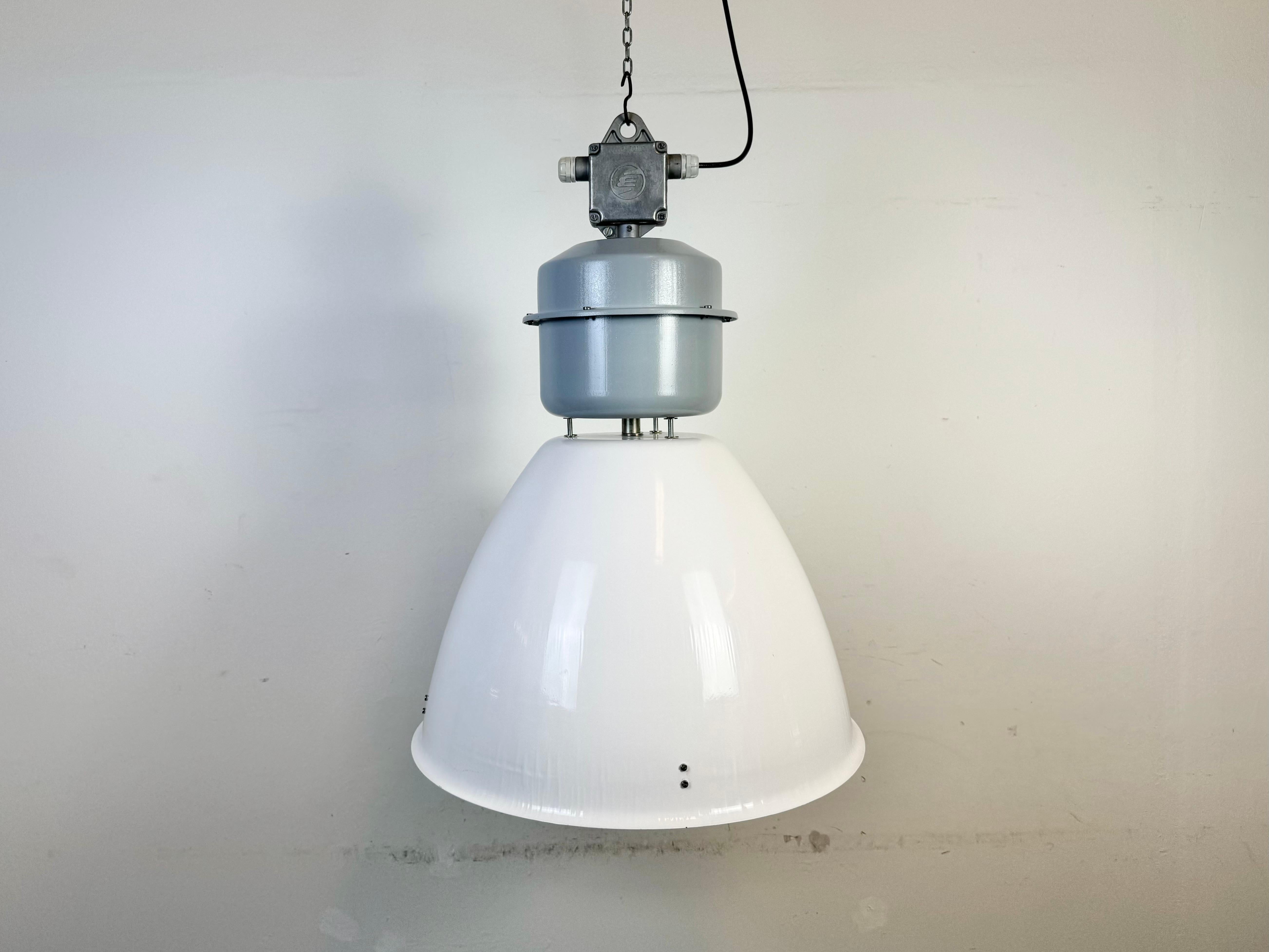 Questa lampada a sospensione industriale è stata realizzata da Elektrosvit in Slovacchia negli anni Novanta. Presenta un paralume in smalto bianco e un piano verniciato grigio con una scatola in fusione di alluminio.
La nuova presa in porcellana