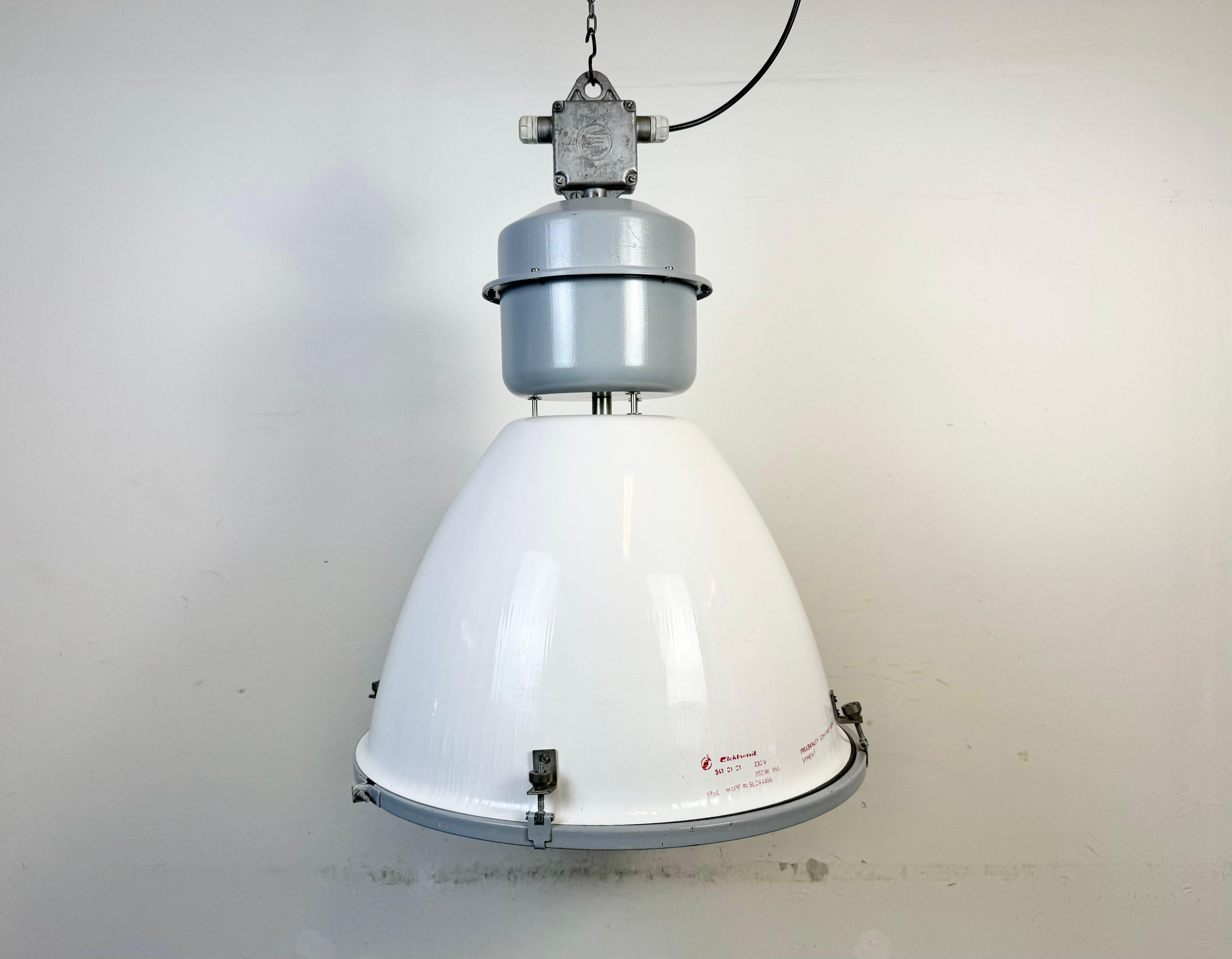 This industrial pendant light was made by Elektrosvit in Slovakia during the 1990s. It features a white enamel shade, a grey painted top with cast aluminium box and clear glass cover.
New porcelain socket requires standard E 27/ E26 lightbulbs . New