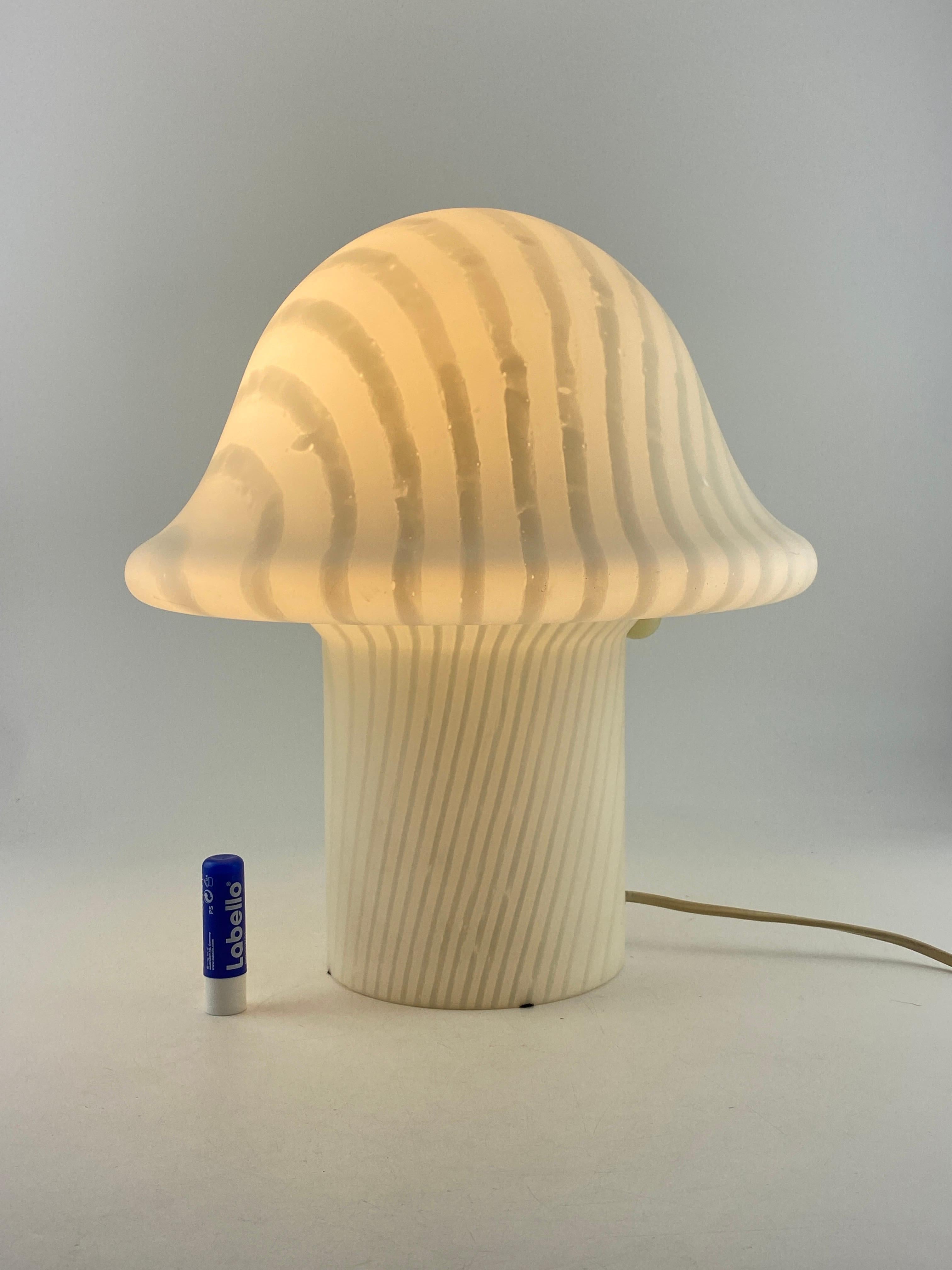 Beautiful German design by Peill and Putzler, produced around 1970 - 1980.

This lamp is made of one mouth-blown piece of crystal glass with a striped print and it's shaped like a typical mid-century mushroom. The lamp is placed directly on the