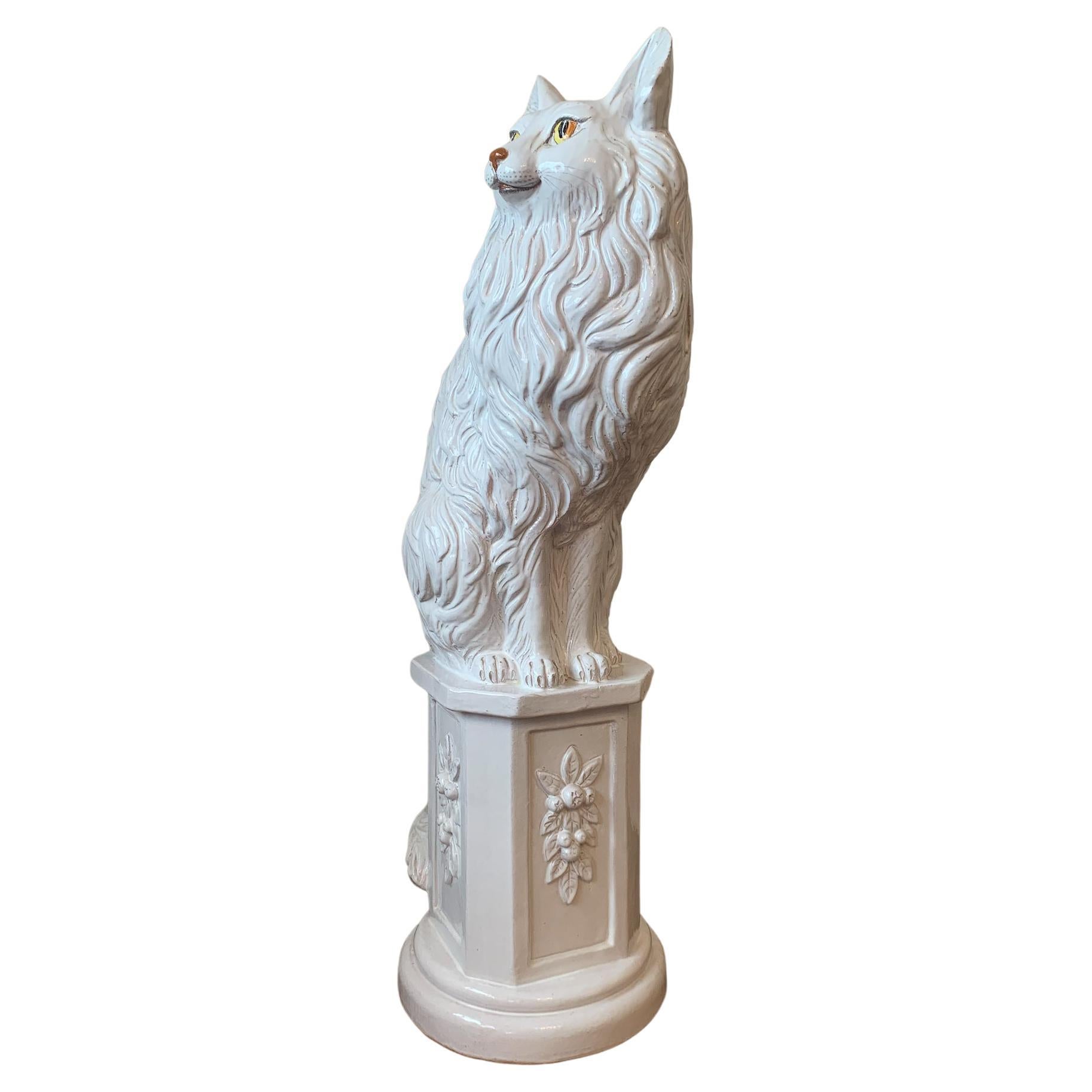 Fabulous larger than life cat or fox sculpture, seated on a pedestal, in white glazed ceramic with attractive yellow-orange eyes. Our foxy friend is one hand-built unit, with evocative MCM styling, and signed inside the hollowed core. There are