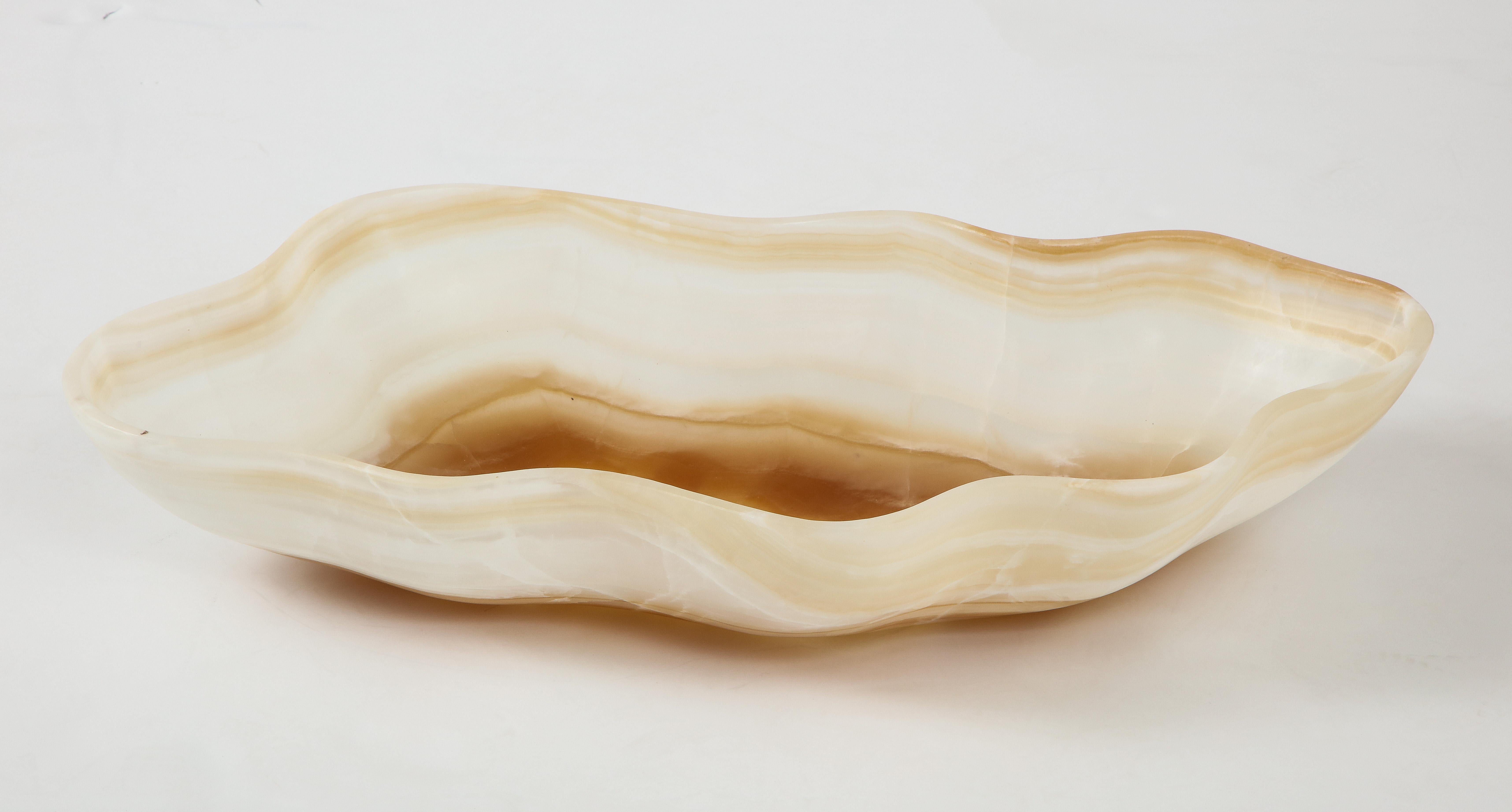 A large white, gold and rust hand carved onyx bowl or centerpiece in an impressive size. Alternating translucent and semi opaque undulating bands of clear, pale gold and rust create an exquisite pattern on this utilitarian and stunning centerpiece.