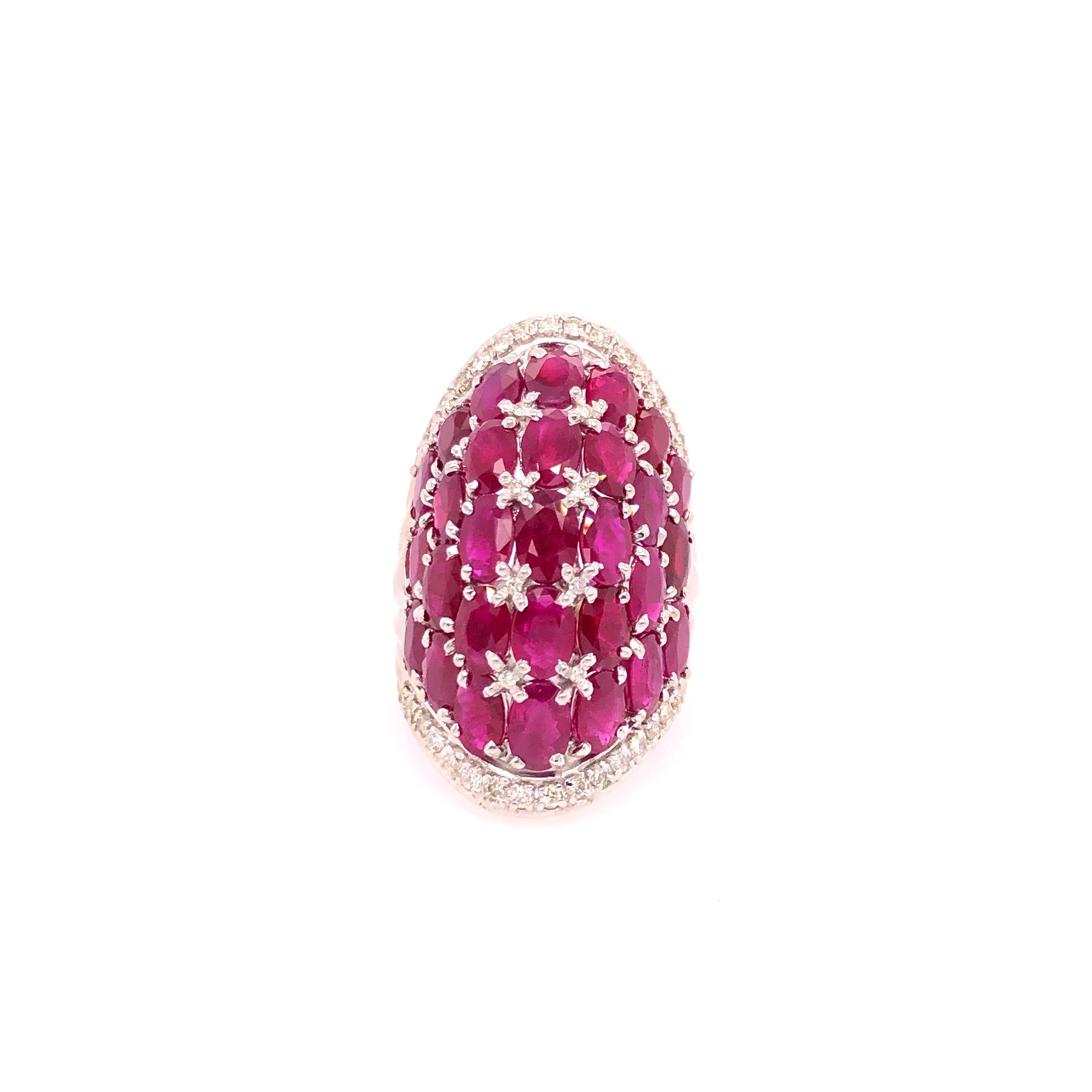 Elegant but bold this ruby and diamond knuckle ring is a show stopper! 29 oval rubies (each measuring about 6mm x 4mm) in 7 rows creates the bowed shape of of the ring. 8 small round diamonds accent the rubies while 32 round diamonds create a