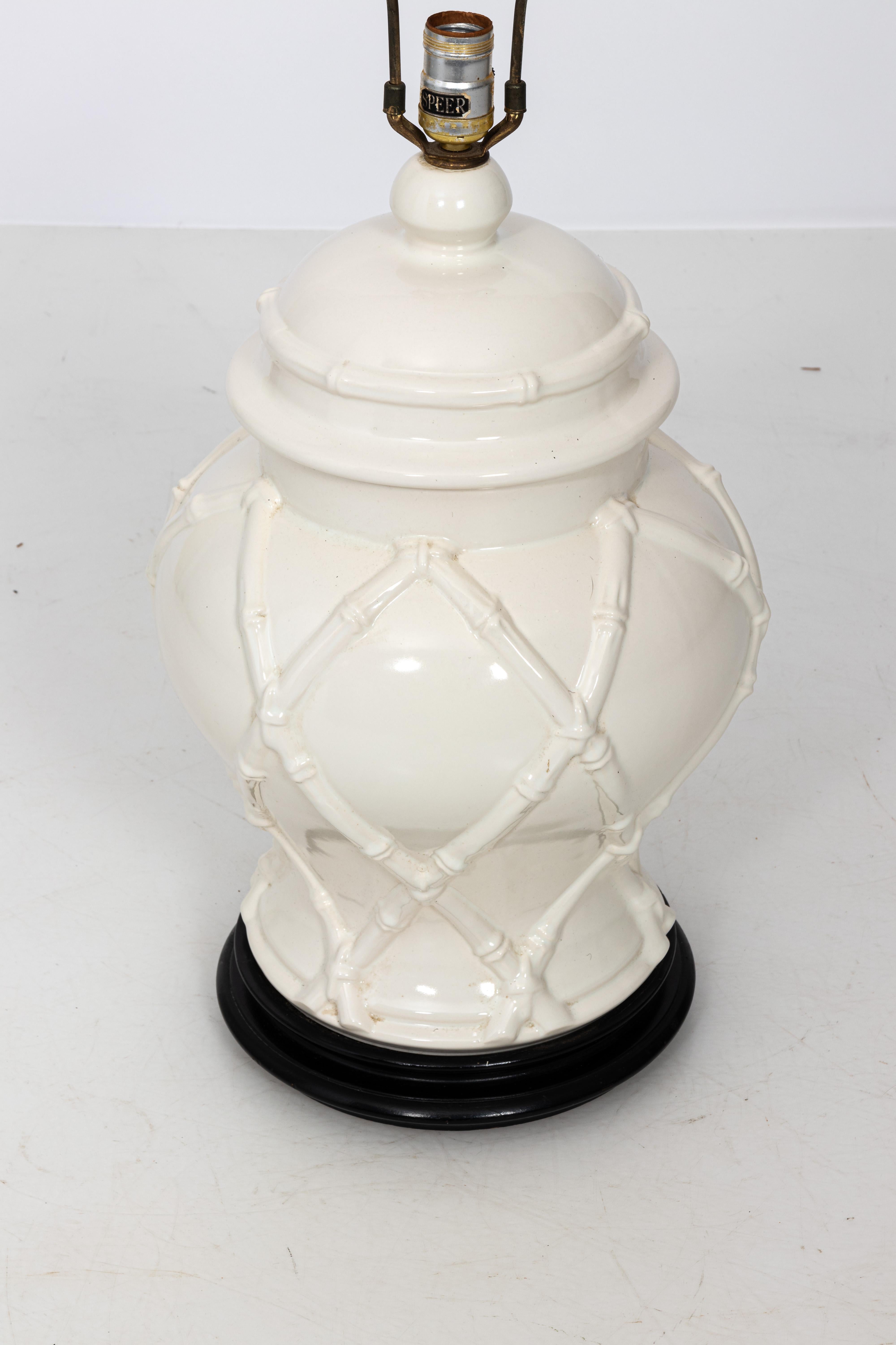 Large Hollywood Regency faux bamboo lamp in white on wood base with original wood finial.