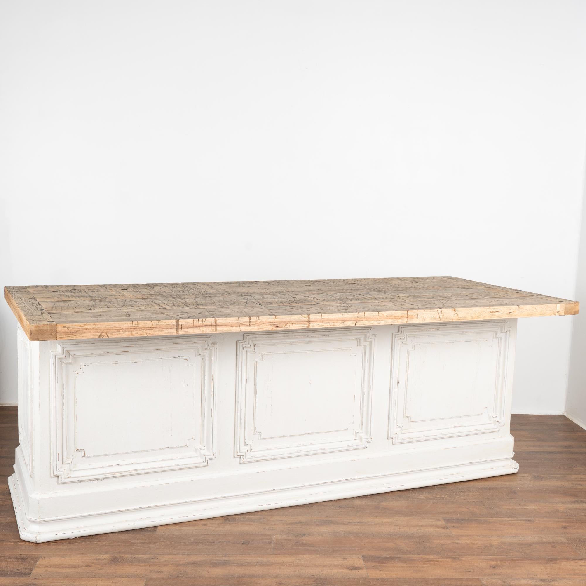 This old shop counter from France has been given new life with a custom professional white painted finish creating a fresh look for a modern kitchen island.
The top is made from old boxcar flooring (from a train); thick and heavy, it is filled with