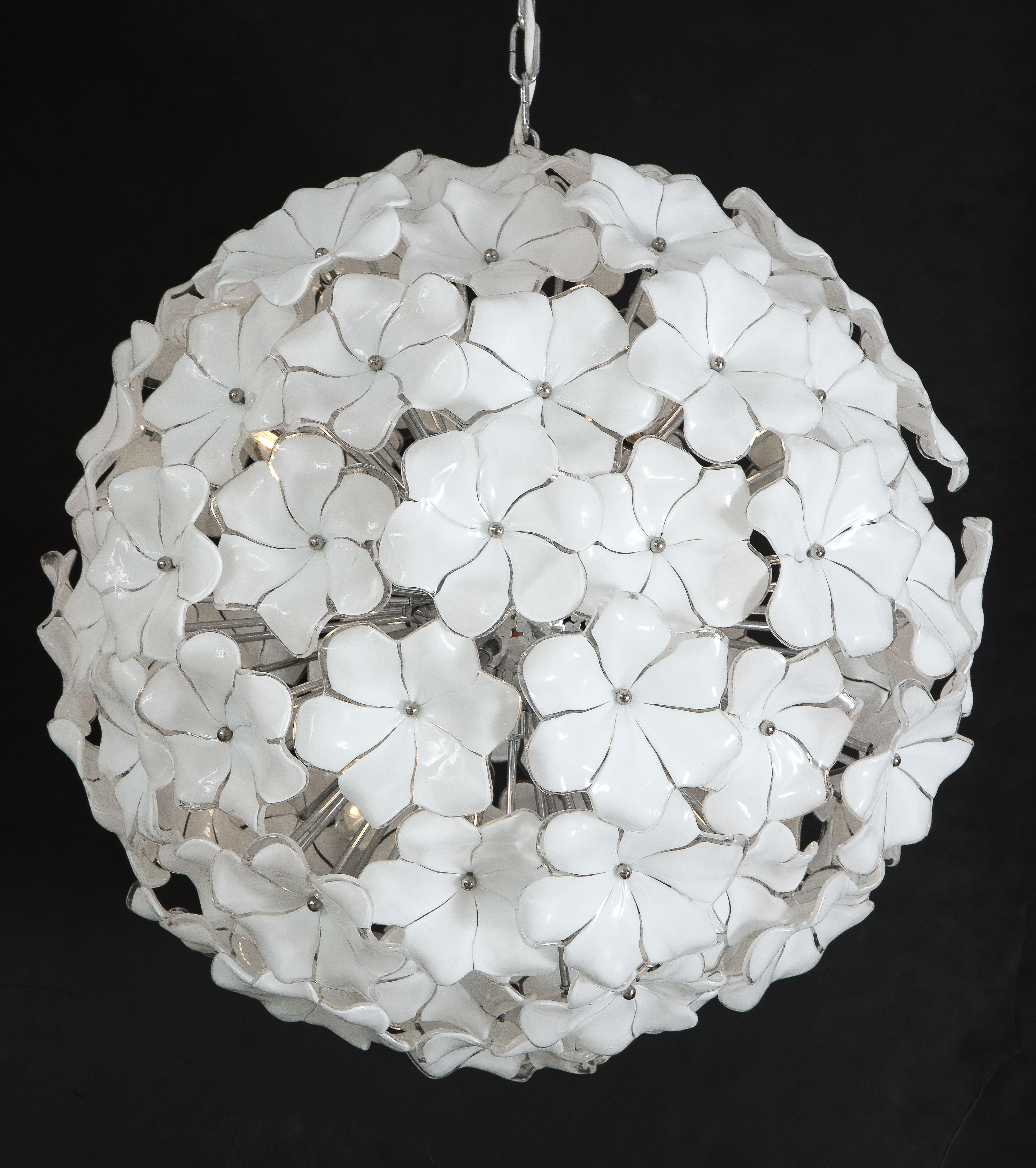 A large 24 inch diameter contemporary Murano globe chandelier featuring opaque and white glass flowers by Cenedese radiating from a polished chrome sphere with six standard sockets wired for the U.S. market that can each accommodate 60 watts